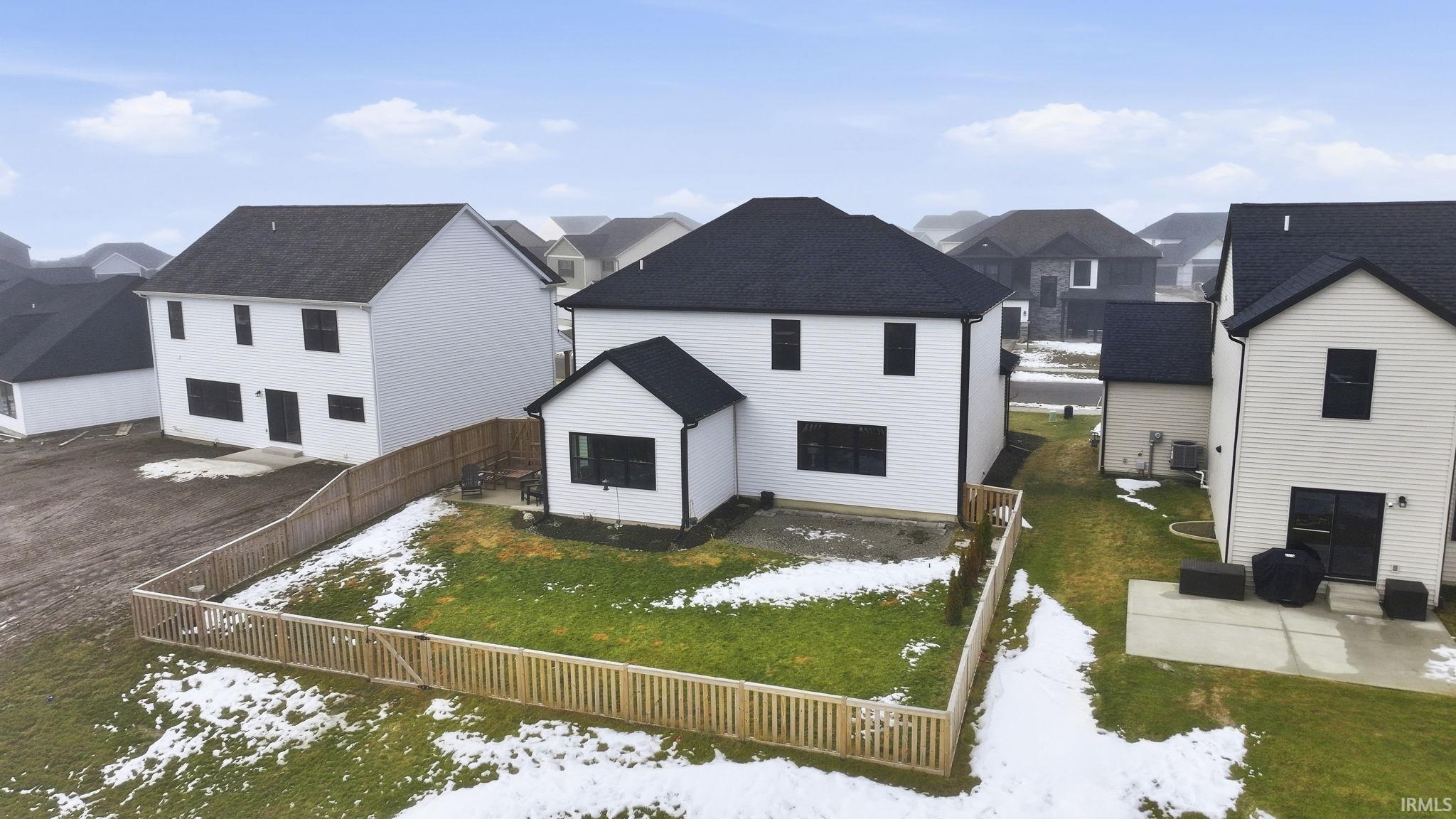 Back of house featuring a residential view, a patio, a fenced backyard, and roof with shingles