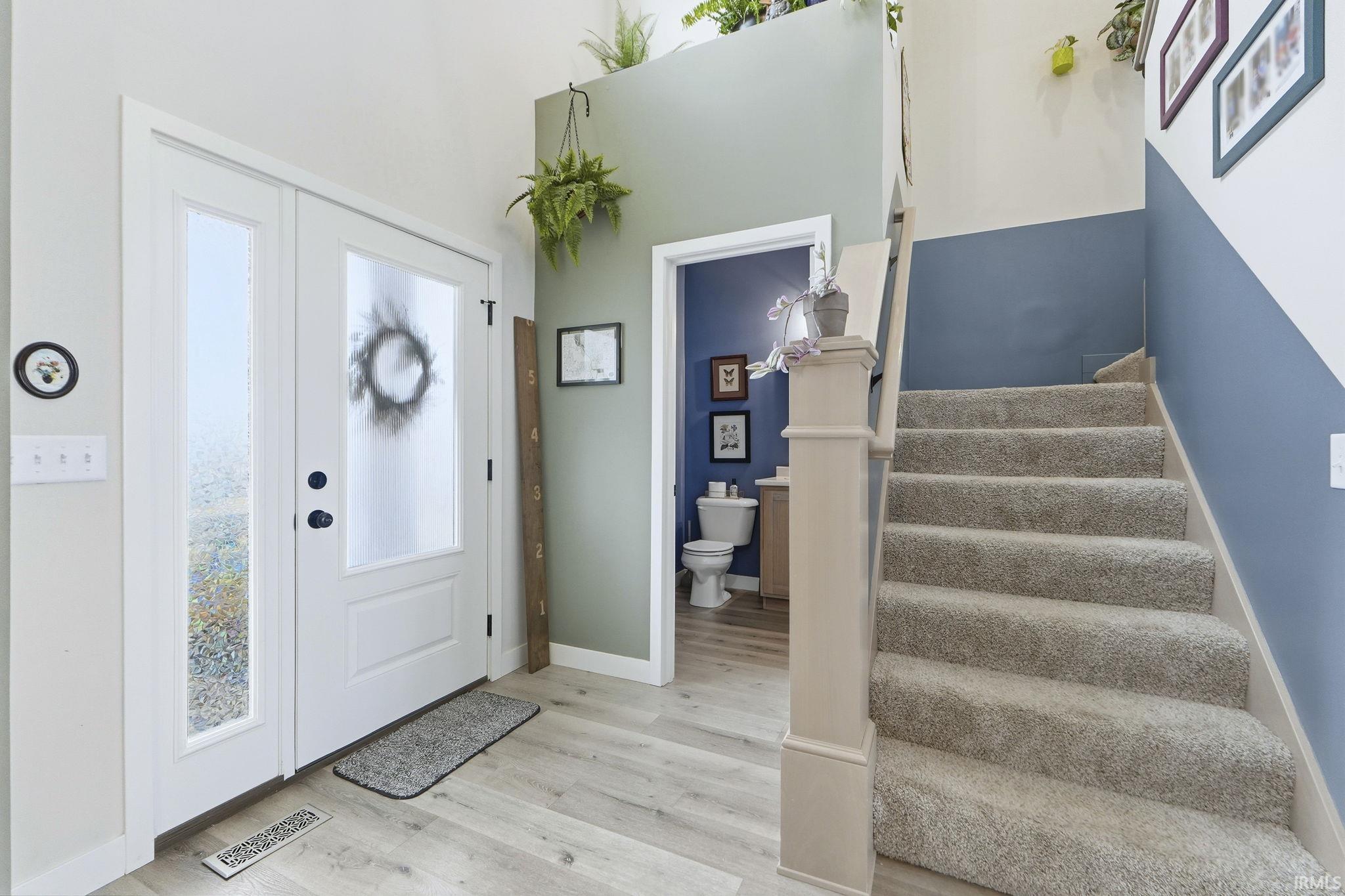Foyer entrance with light wood-type flooring and a high ceiling