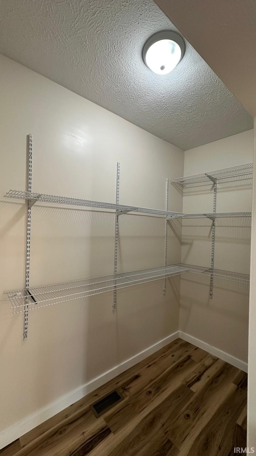 Pantry featuring dark wood-type flooring