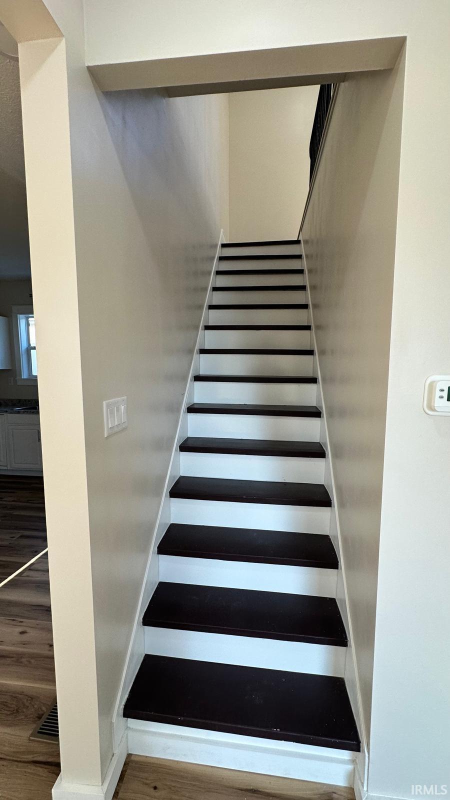 Staircase featuring wood finished floors