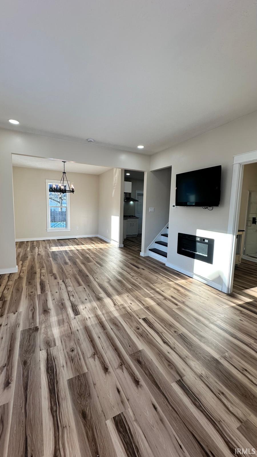 Unfurnished living room with light wood-type flooring, recessed lighting, and a fireplace