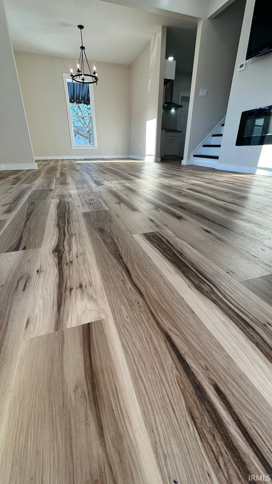 Unfurnished dining area featuring a chandelier and wood finished floors