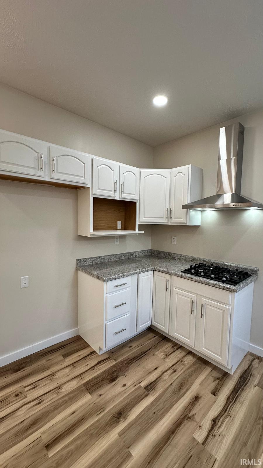 Kitchen with white cabinetry, light wood-style floors, black gas cooktop, and recessed lighting
