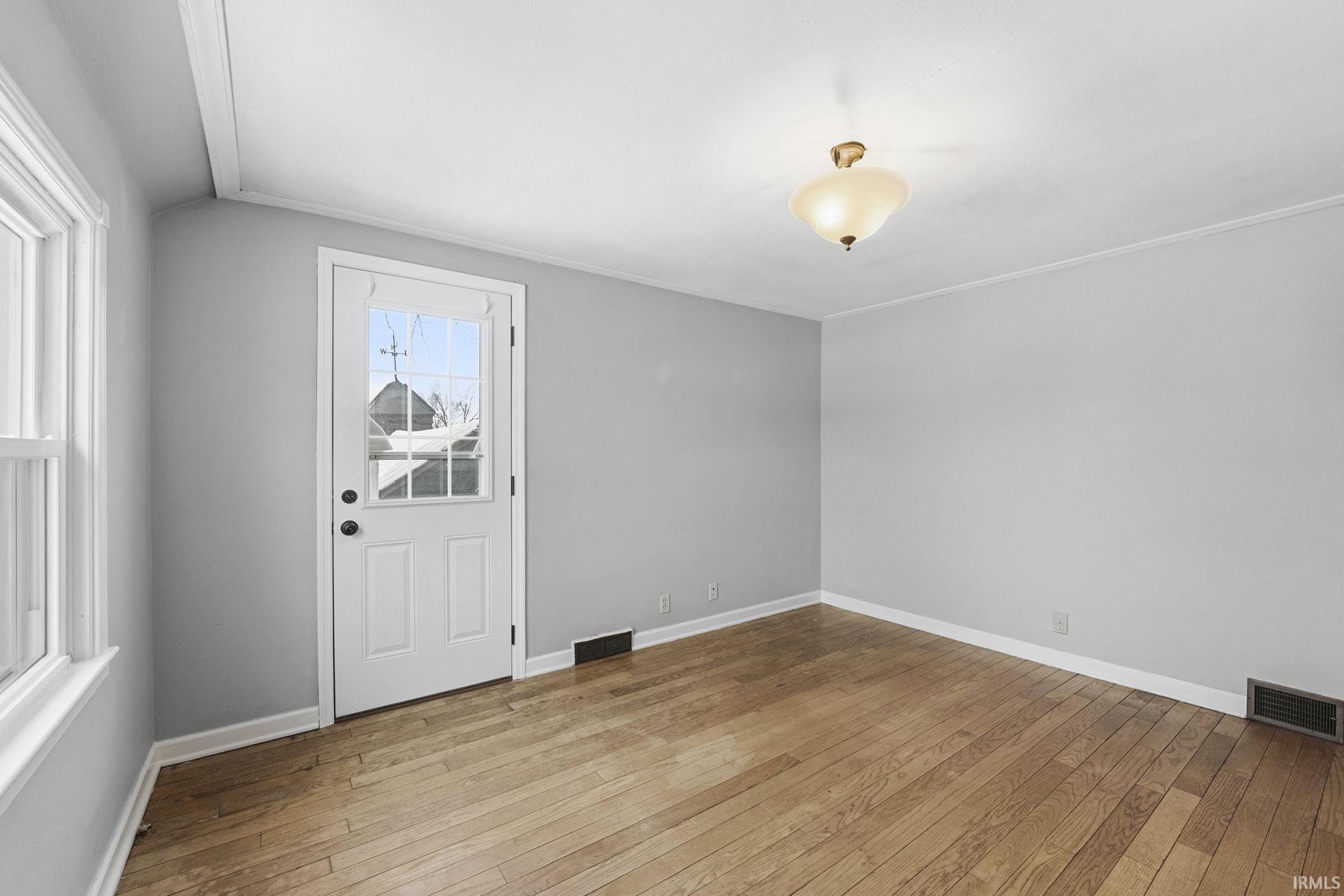 Foyer featuring light wood-type flooring and ornamental molding