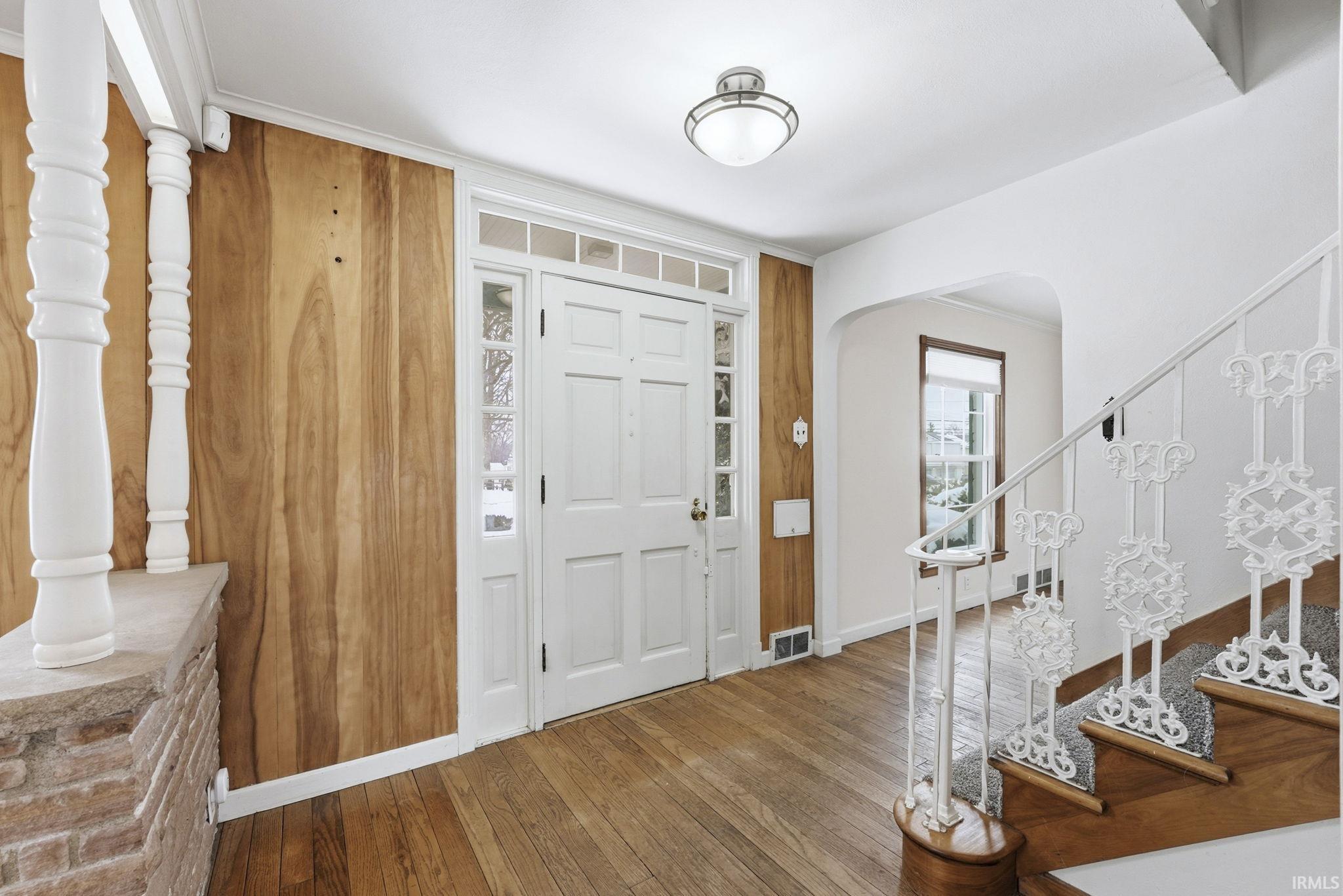 Entryway featuring arched walkways and hardwood / wood-style floors