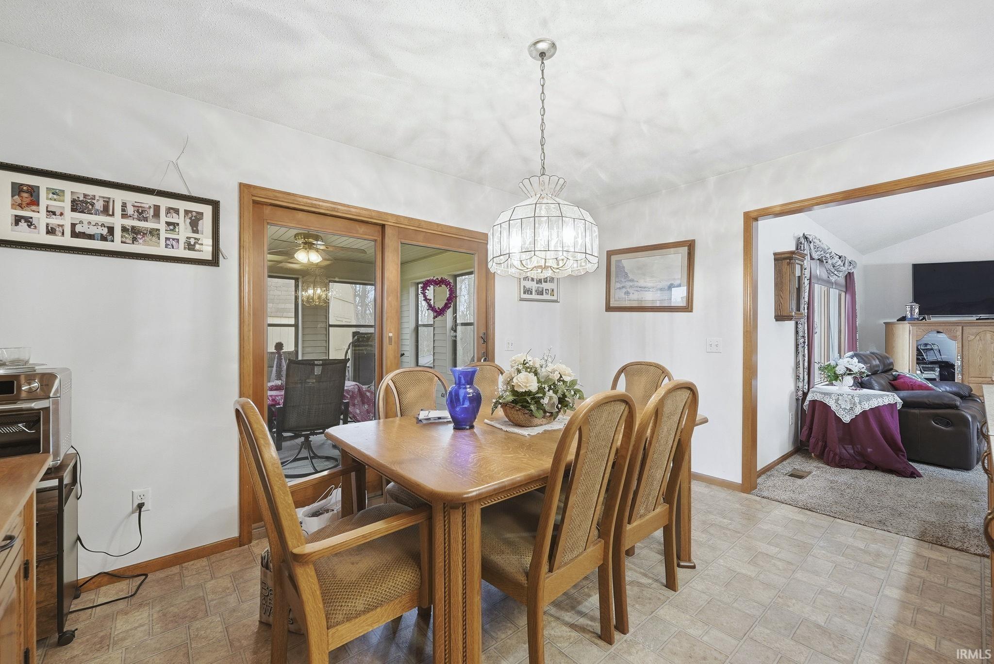 Dining space featuring suspended lighting, lofted ceiling, and ceiling fan
