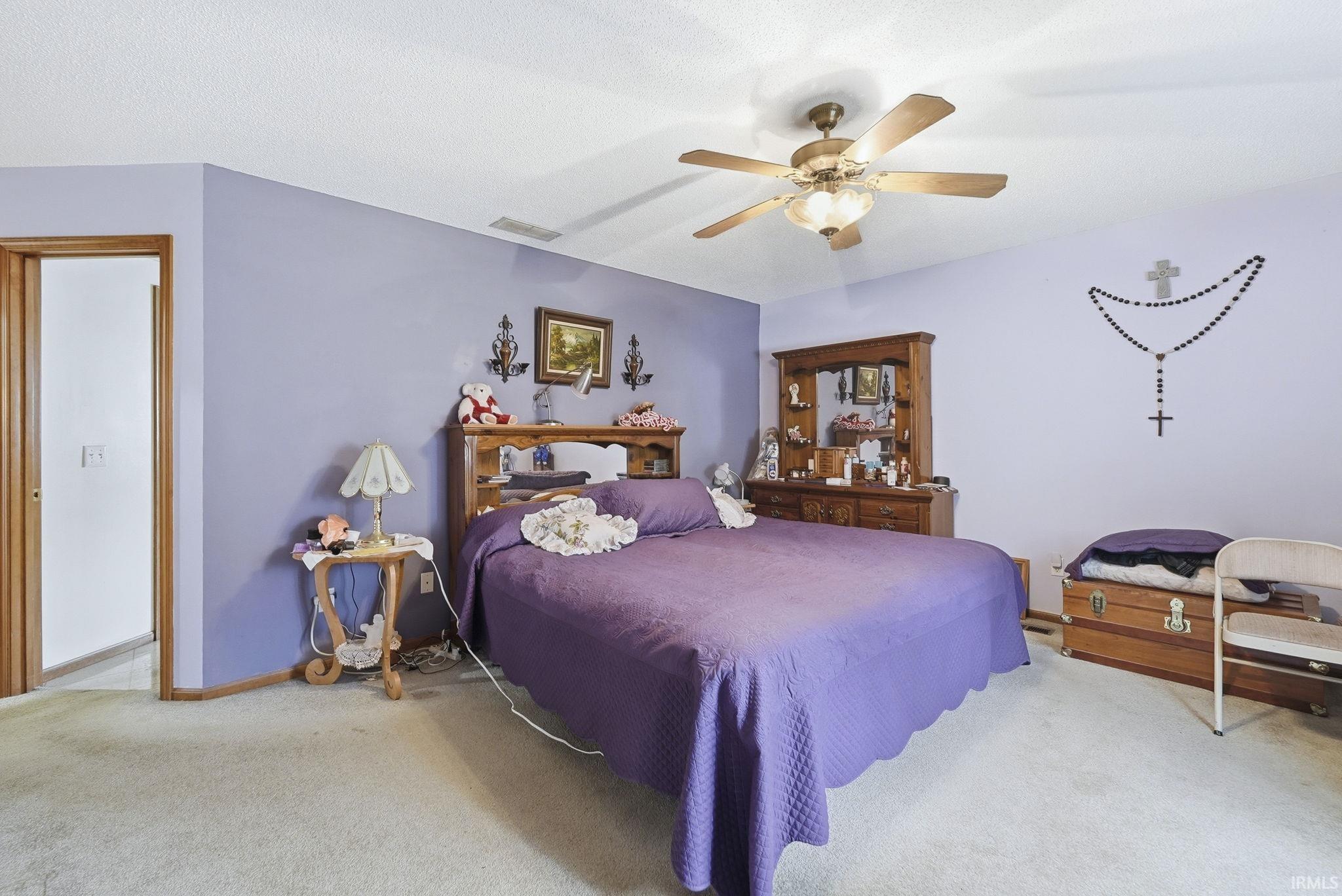 Bedroom with light carpet and a ceiling fan