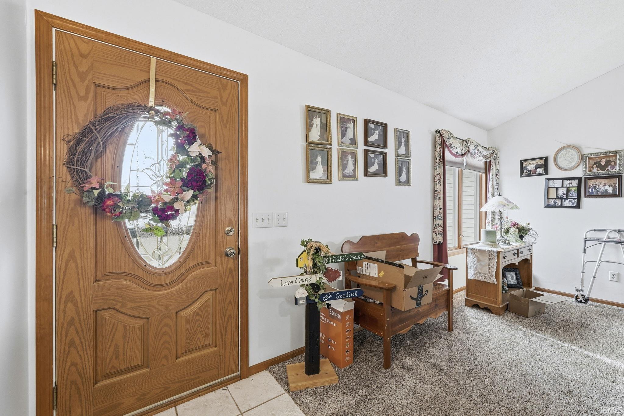 Foyer featuring lofted ceiling and light carpet