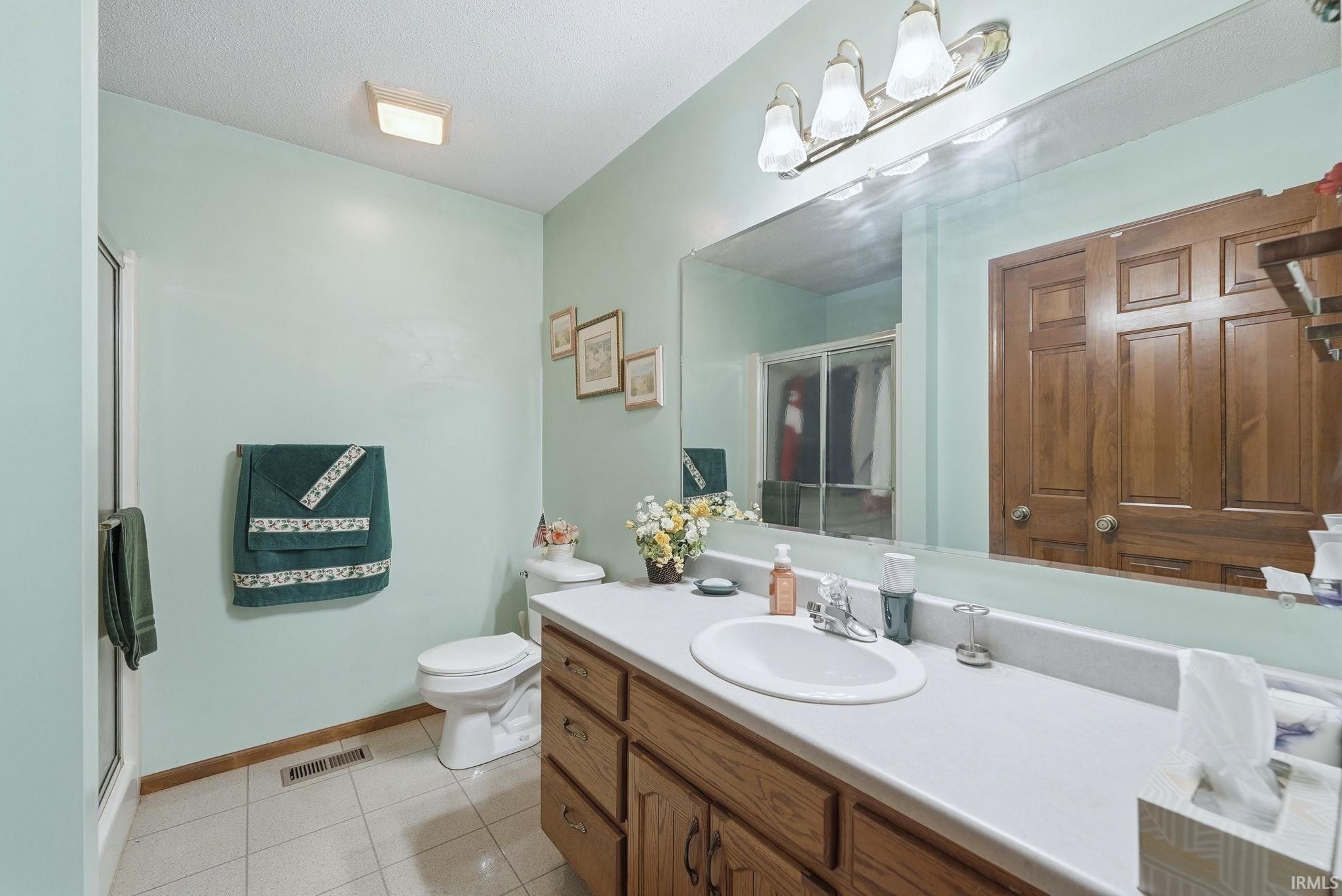 Bathroom with a stall shower, vanity, and light tile patterned floors