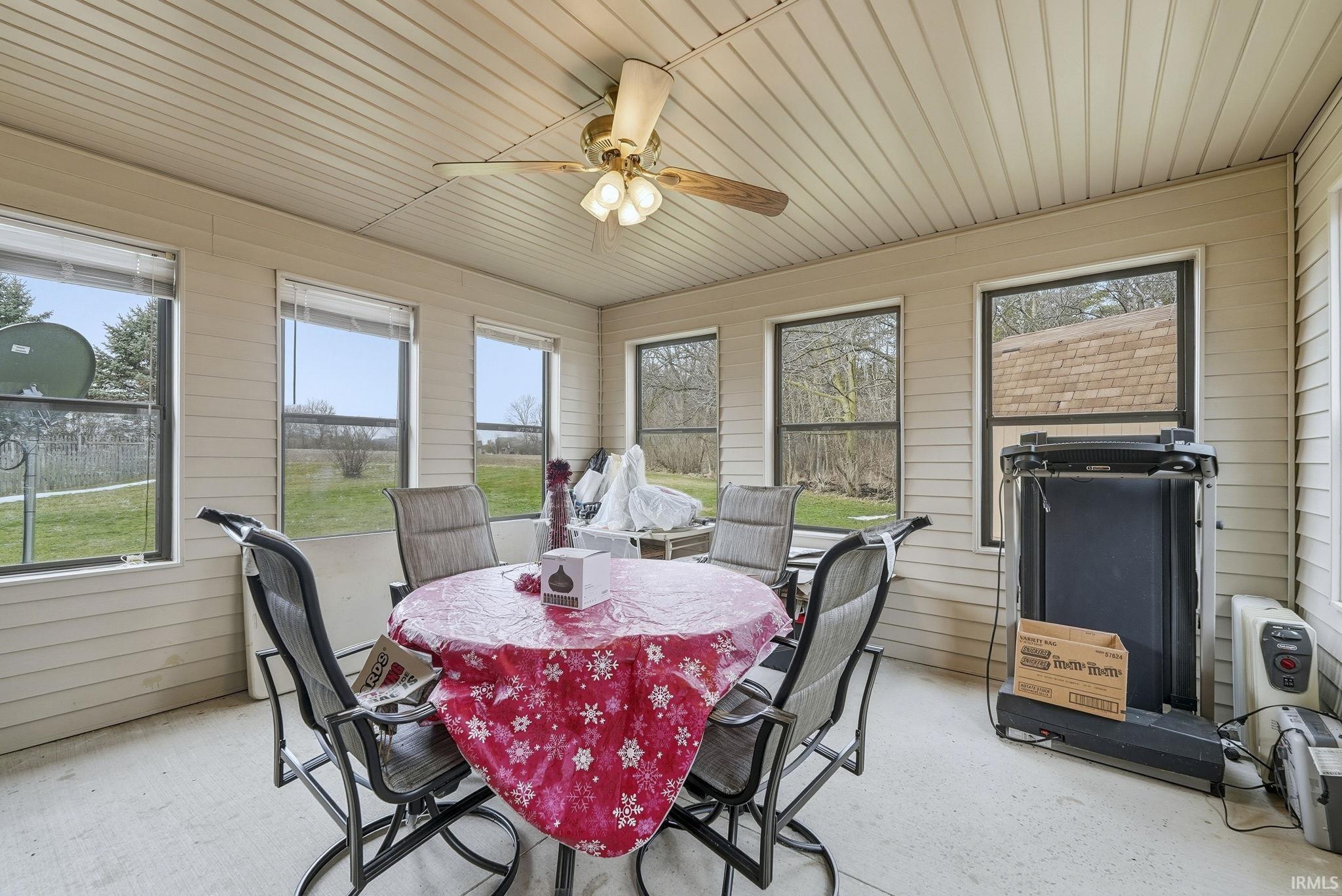 Sunroom featuring a ceiling fan and outdoor dining area