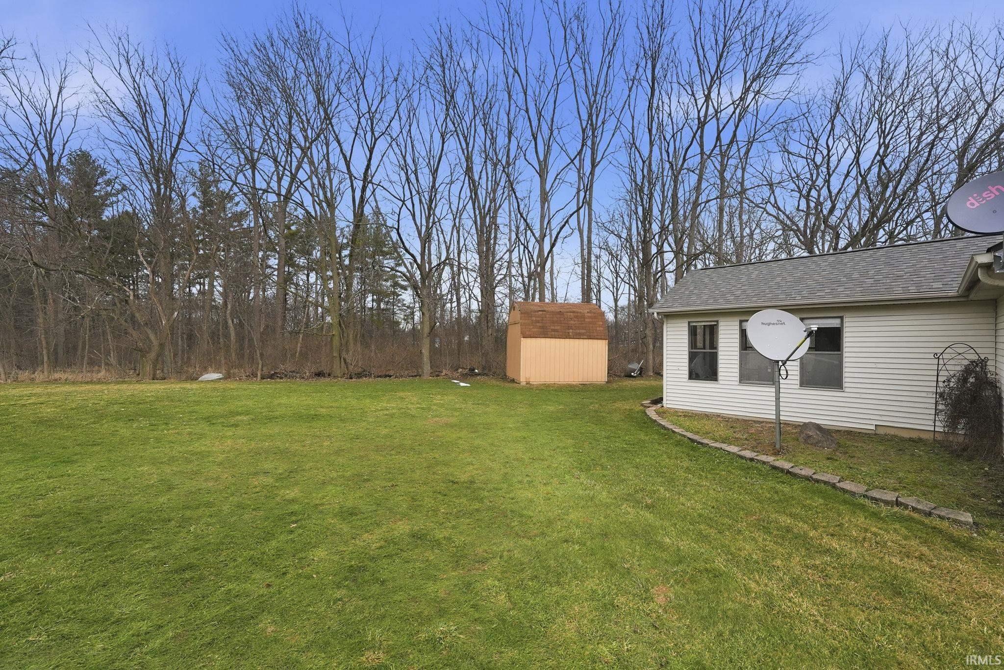 View of grassy yard featuring a storage shed