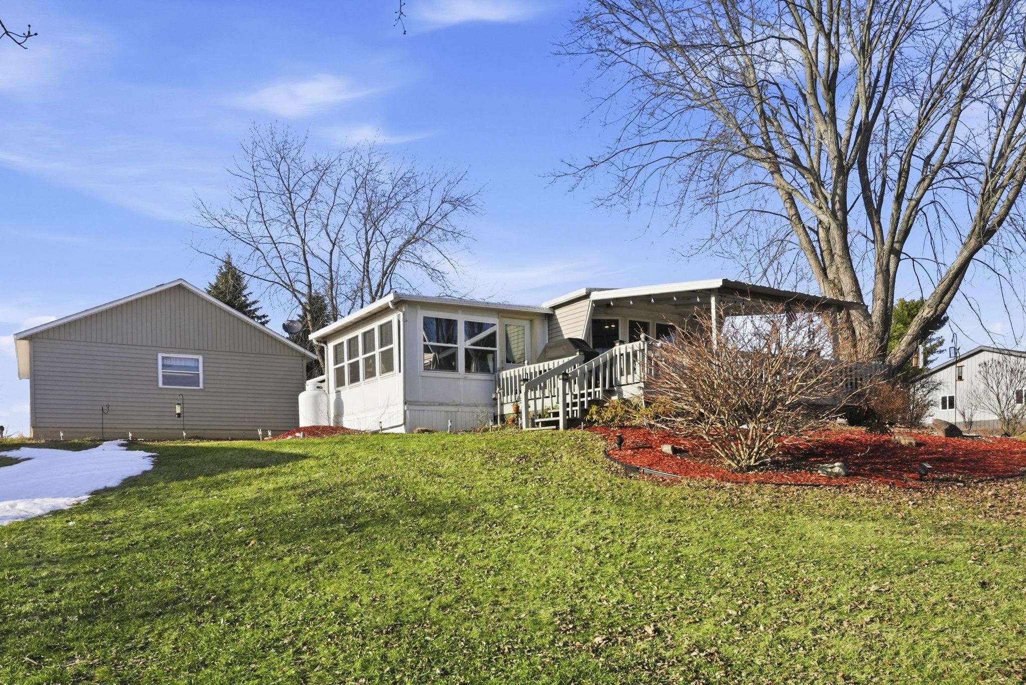 Rear view of house with a wooden deck and a yard