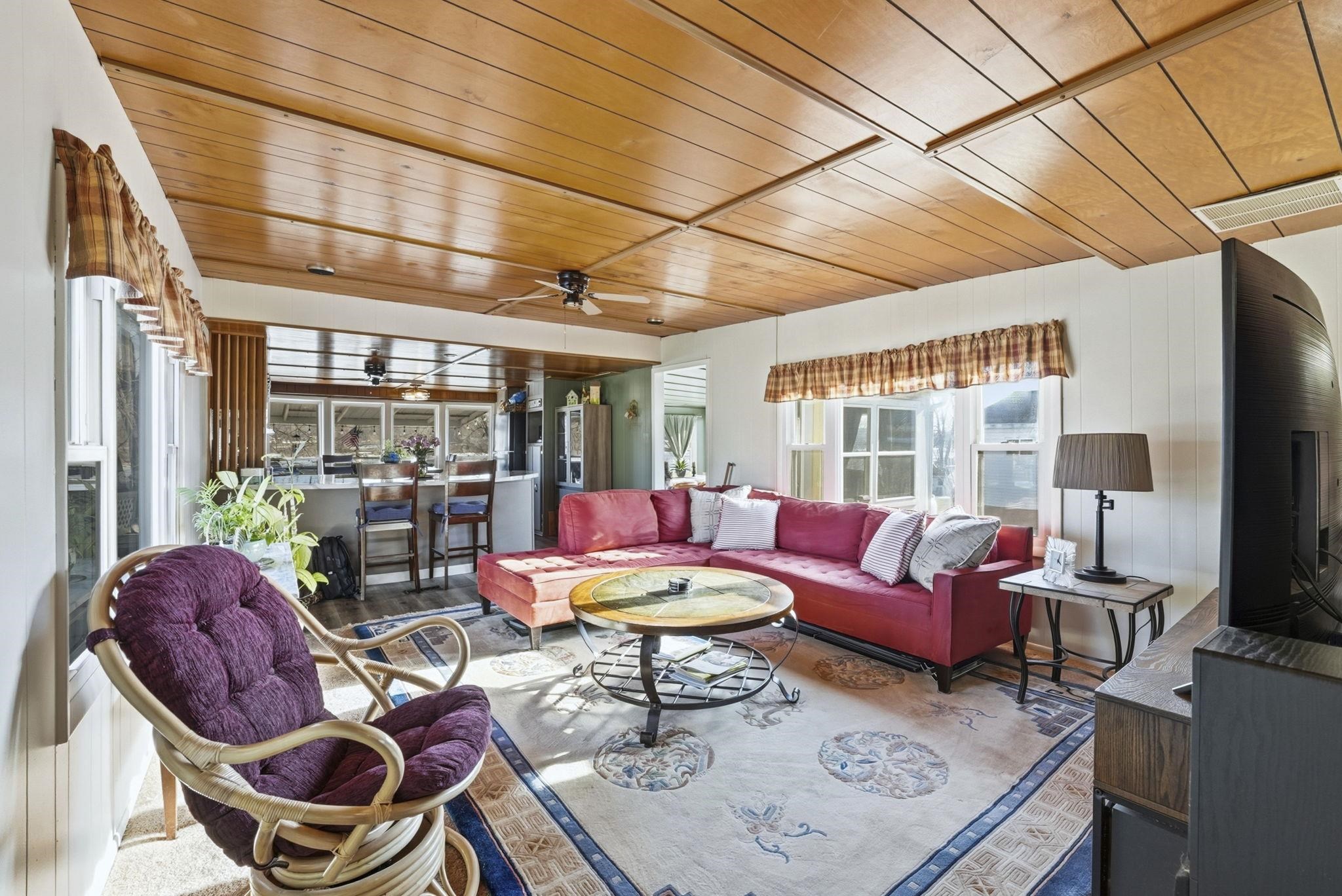 Living room featuring wooden ceiling, wood finished floors, and ceiling fan