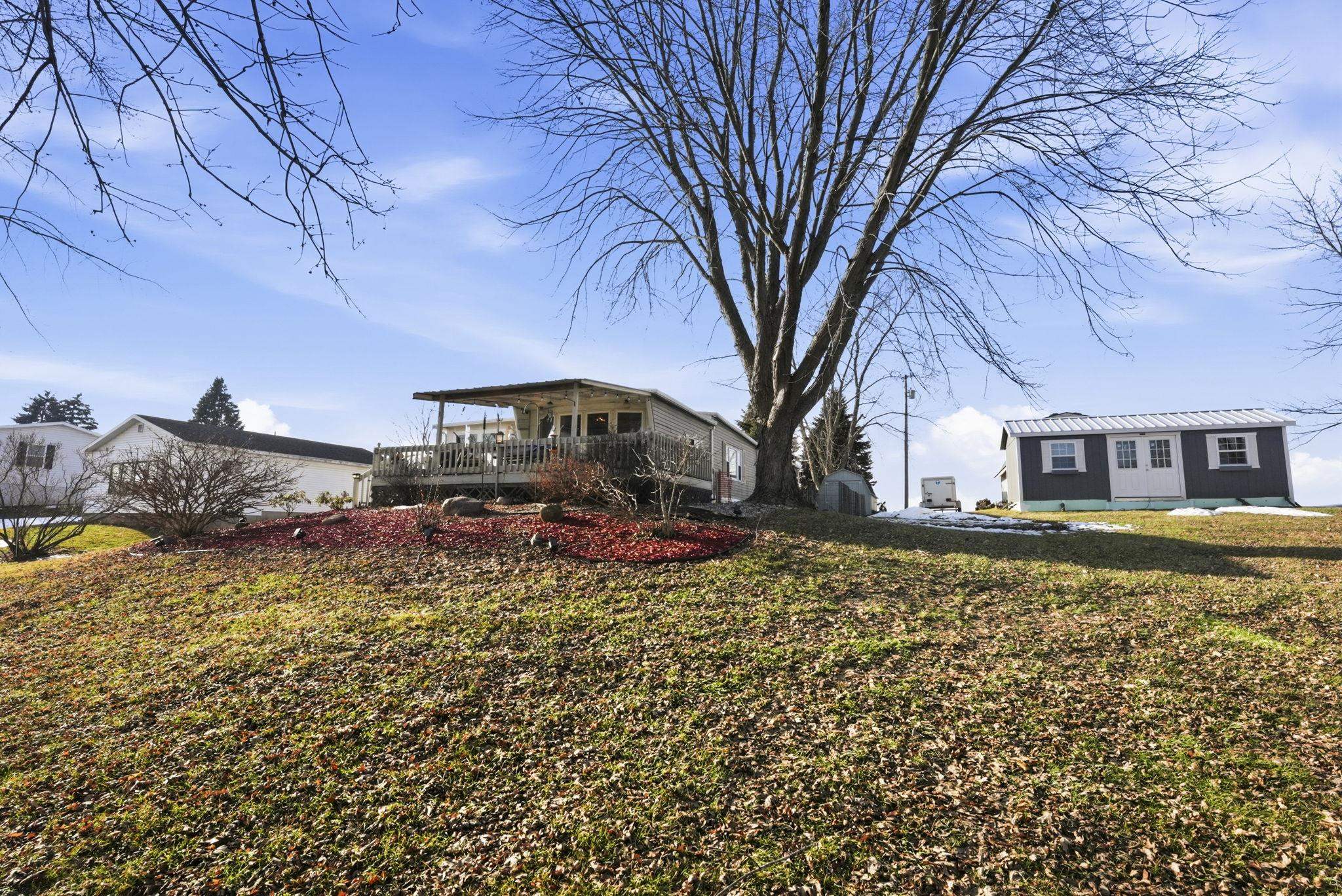 View of grassy yard featuring an outbuilding and a deck