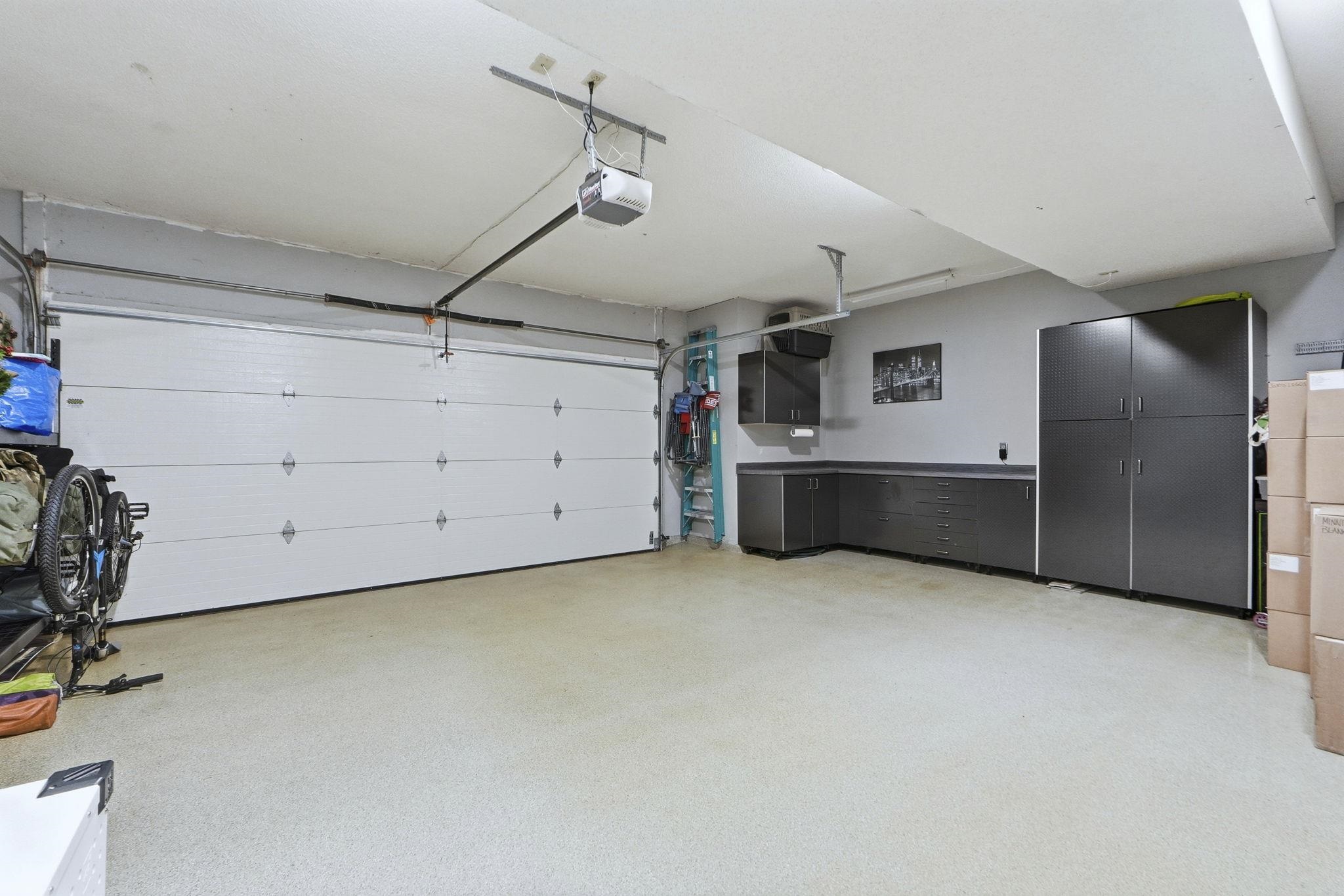Oversized 2 car garage with epoxy stained flooring and large built in storage cabinets