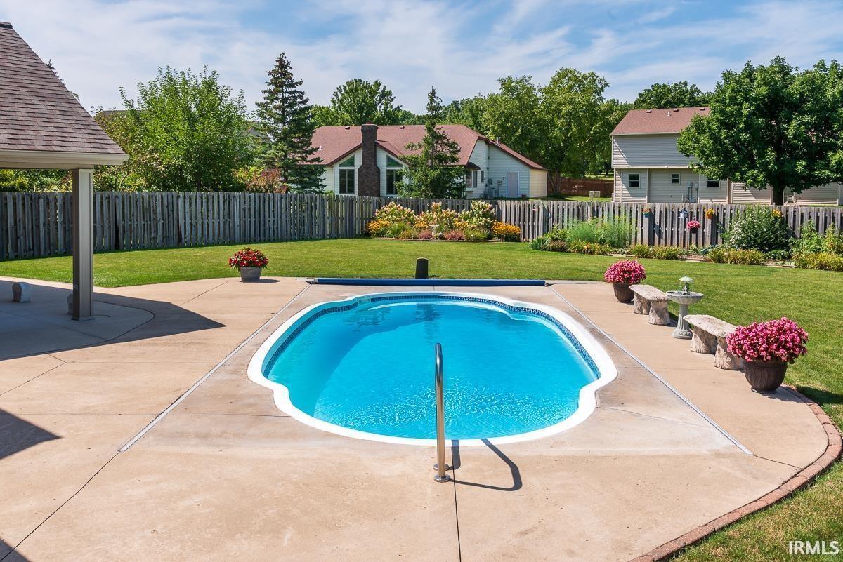 View of swimming pool featuring patio surround and a fenced backyard