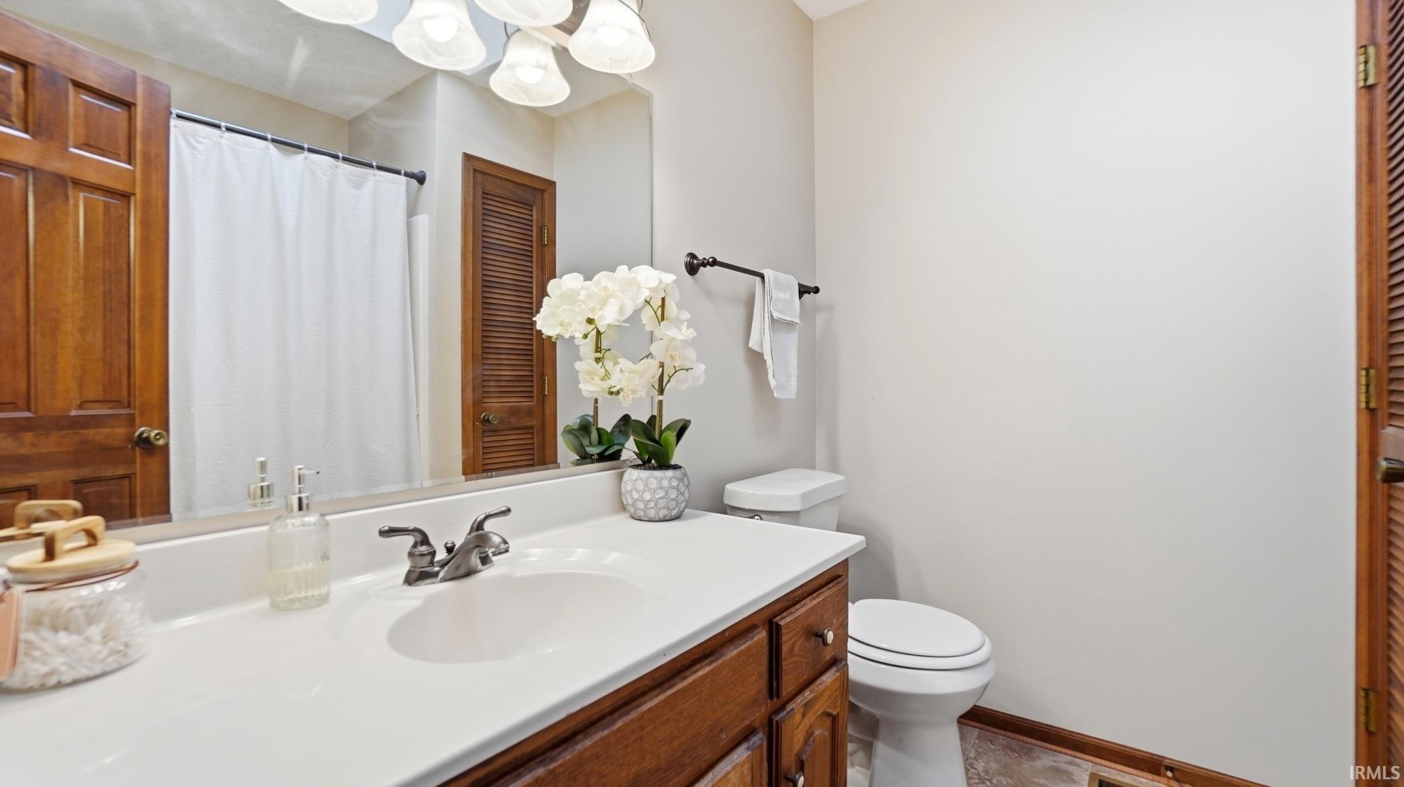 Full bath featuring vanity, a shower with curtain, and a closet