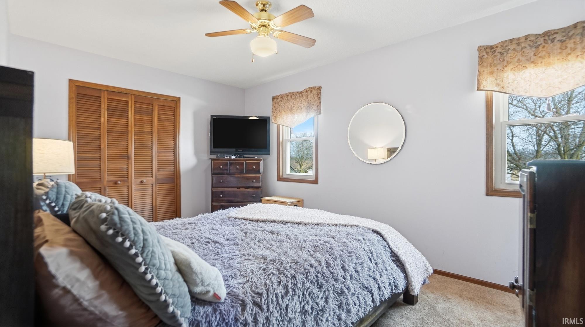 Bedroom featuring carpet flooring, ceiling fan, and a closet