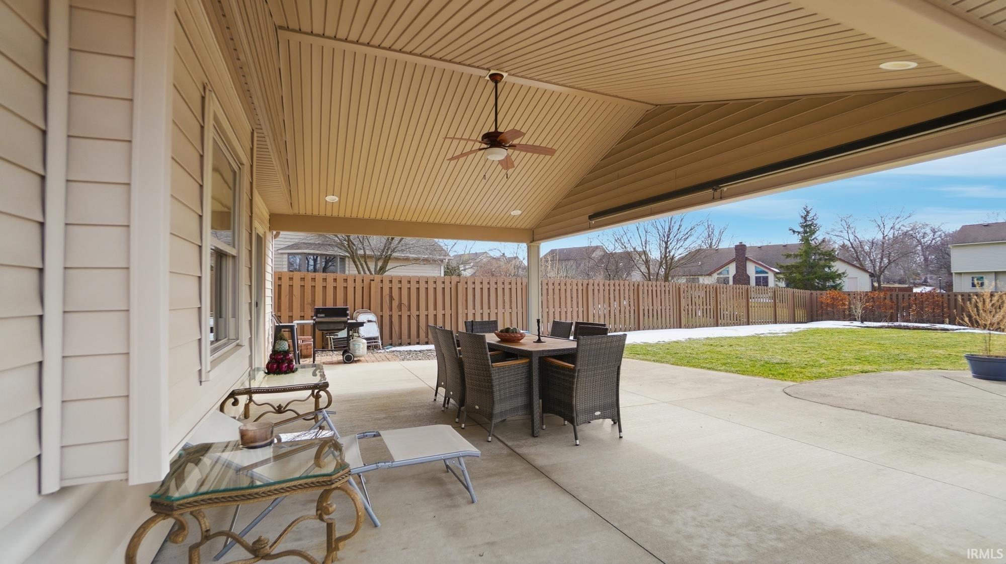 Fenced backyard with ceiling fan, a patio area, and outdoor dining area