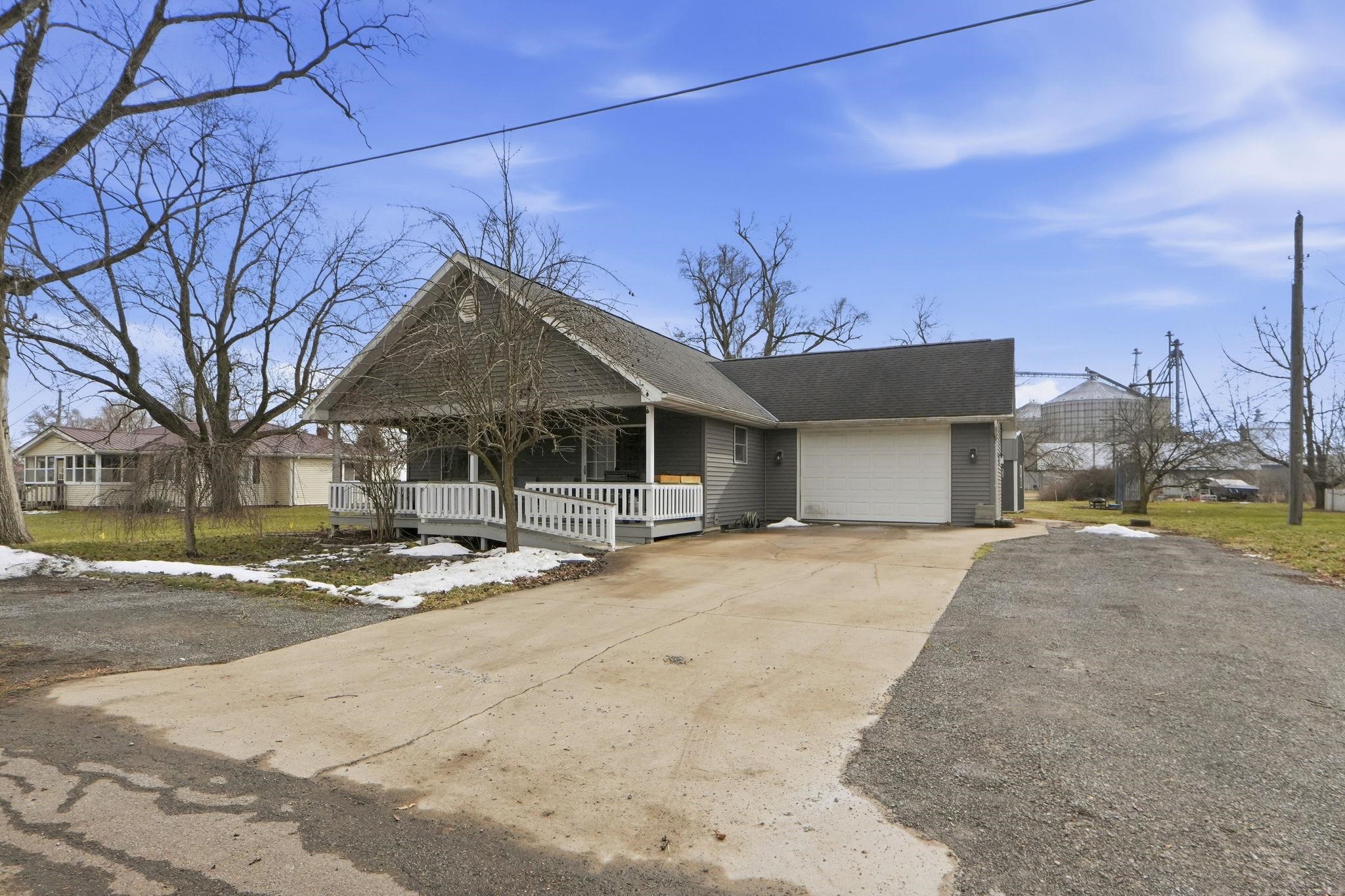 View of front of home with concrete driveway, covered porch, and a garage