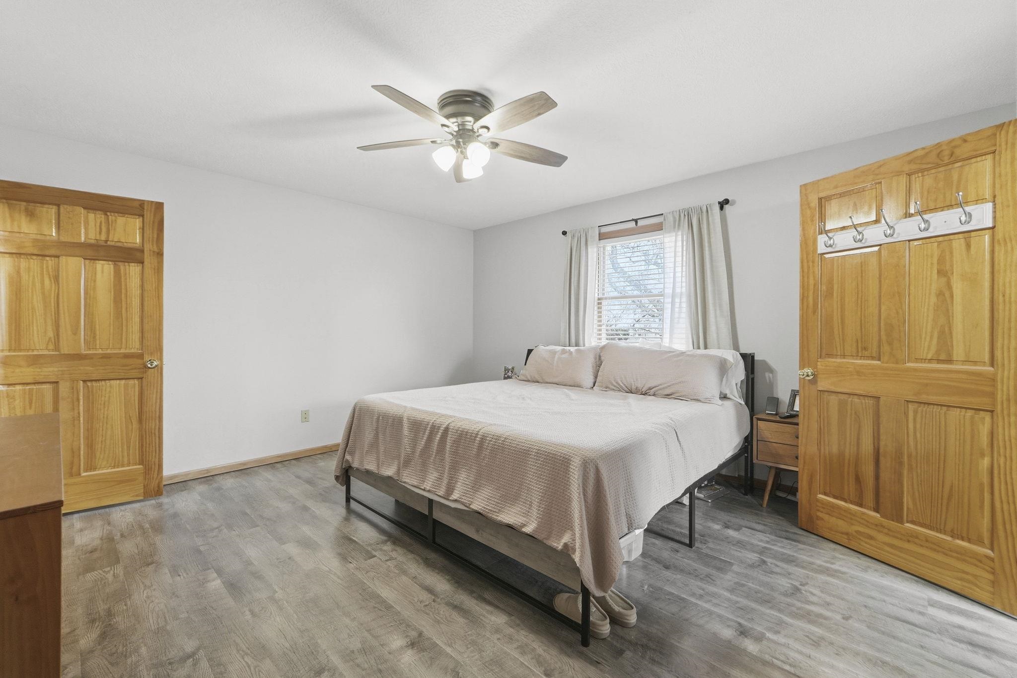 Bedroom with light wood-type flooring and a ceiling fan