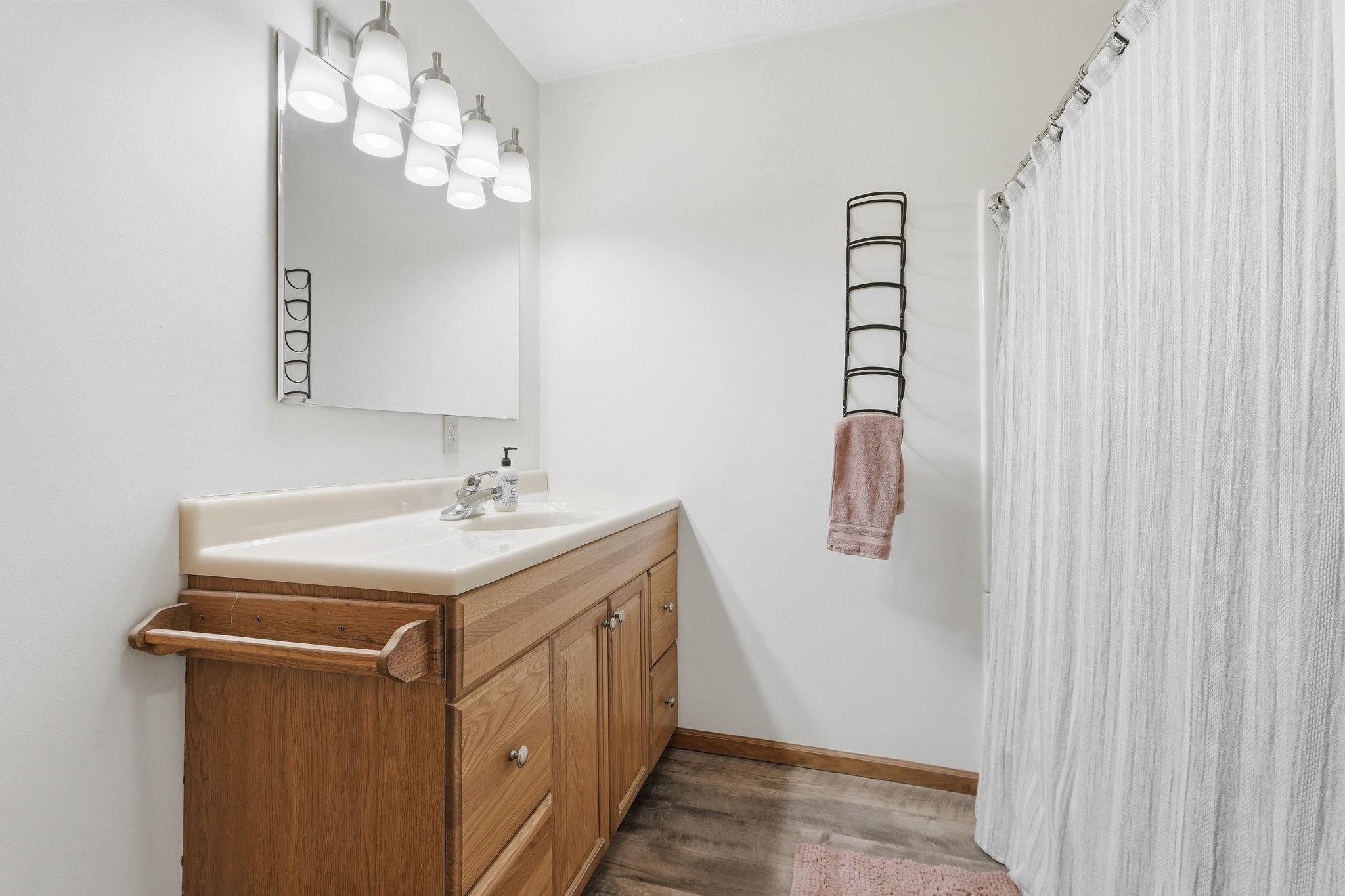 Full bathroom featuring vanity, a shower with curtain, and dark wood finished floors