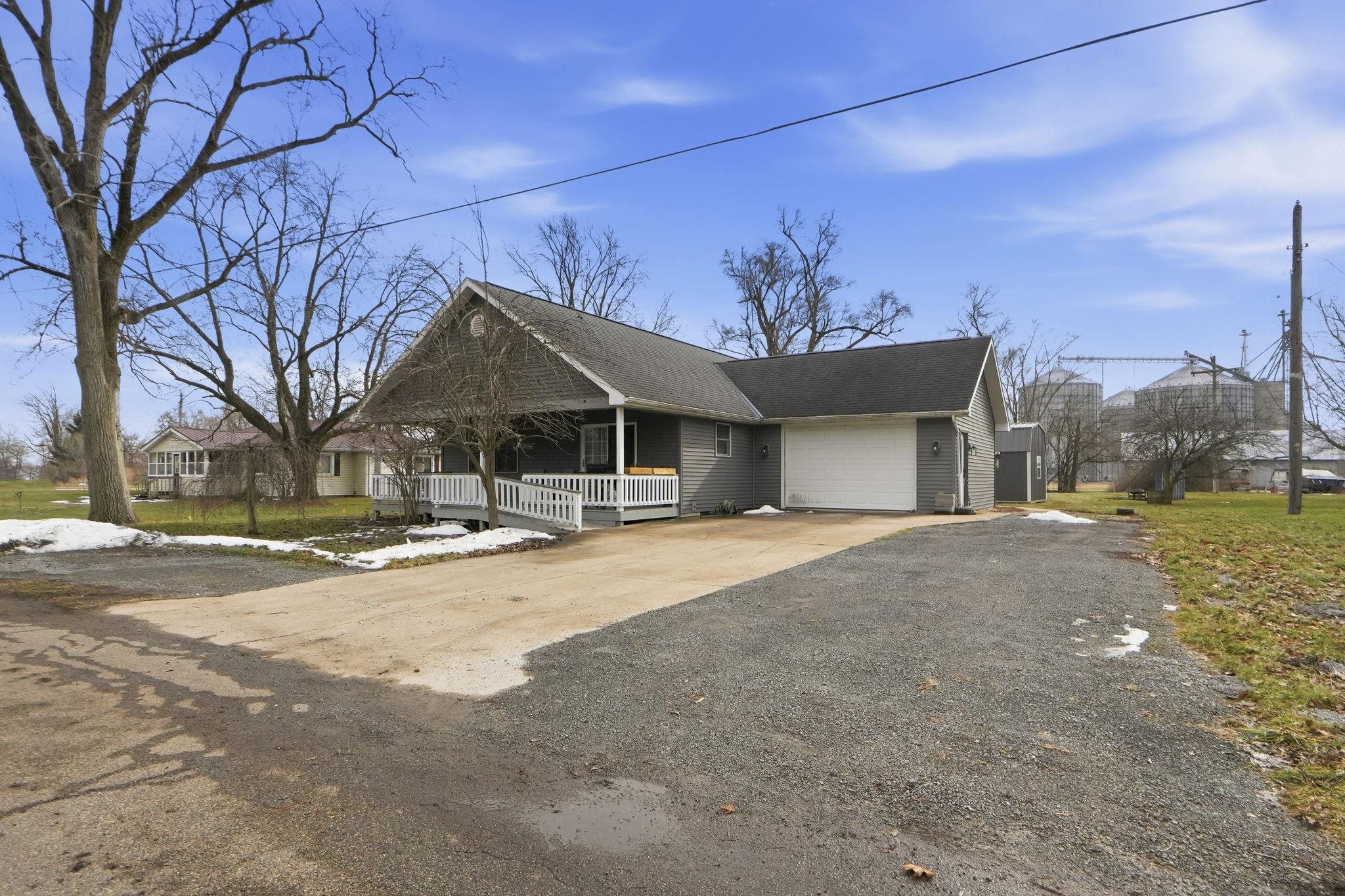 View of front of property featuring covered porch, concrete driveway, and a garage