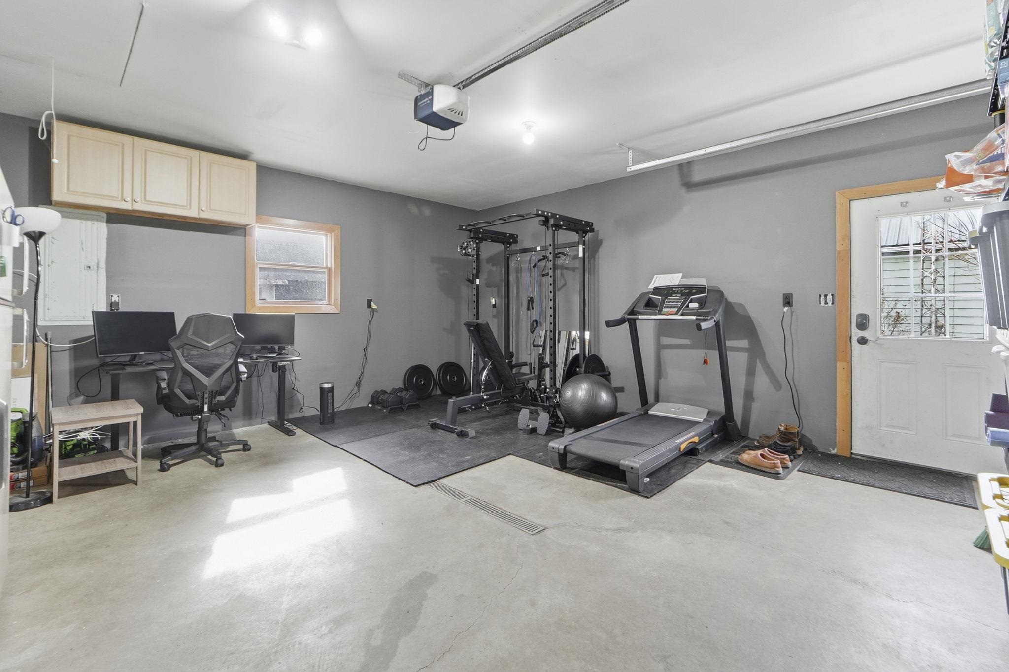 Workout room featuring concrete flooring and a garage