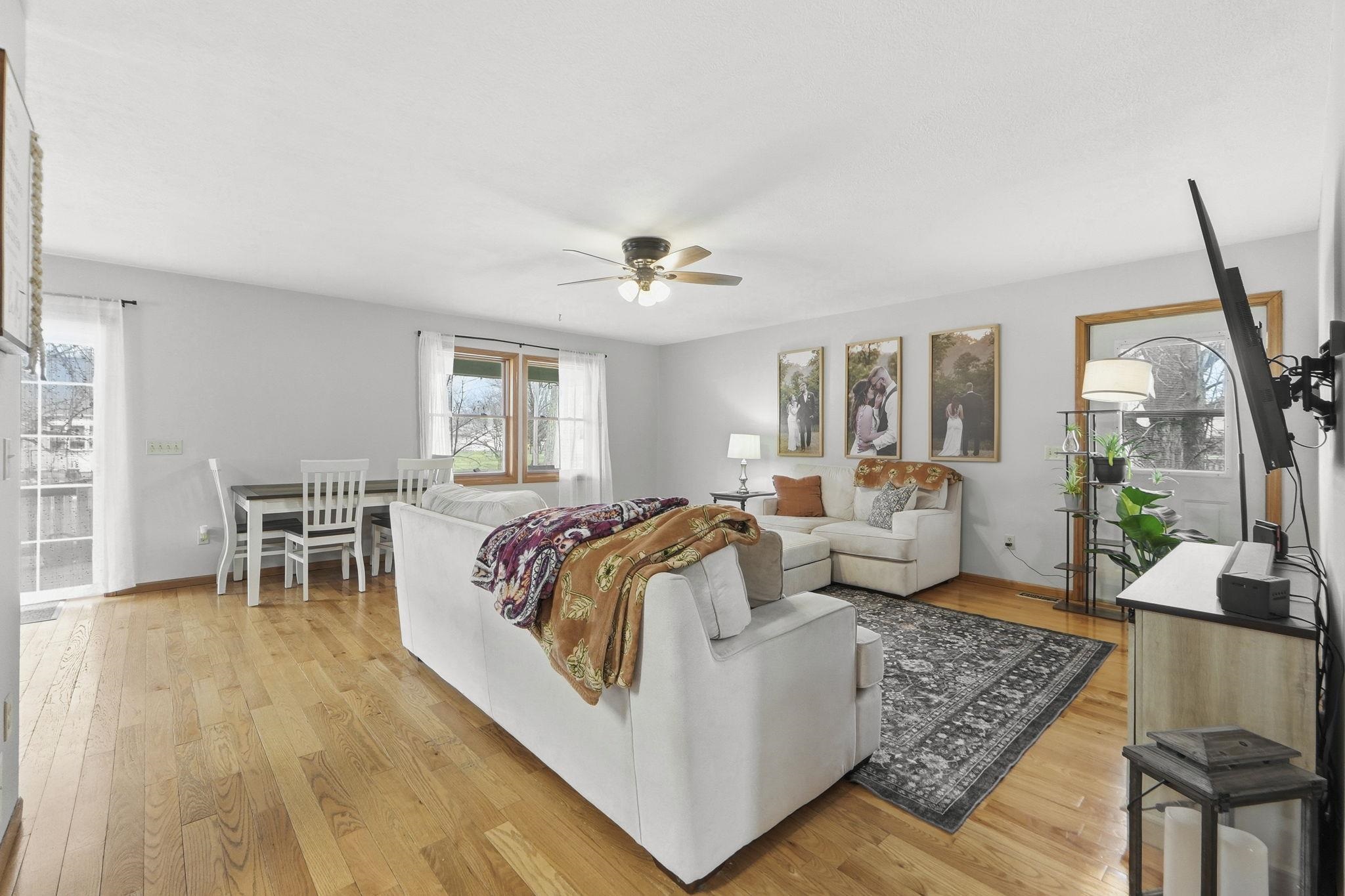 Living area featuring light wood-style floors and a ceiling fan