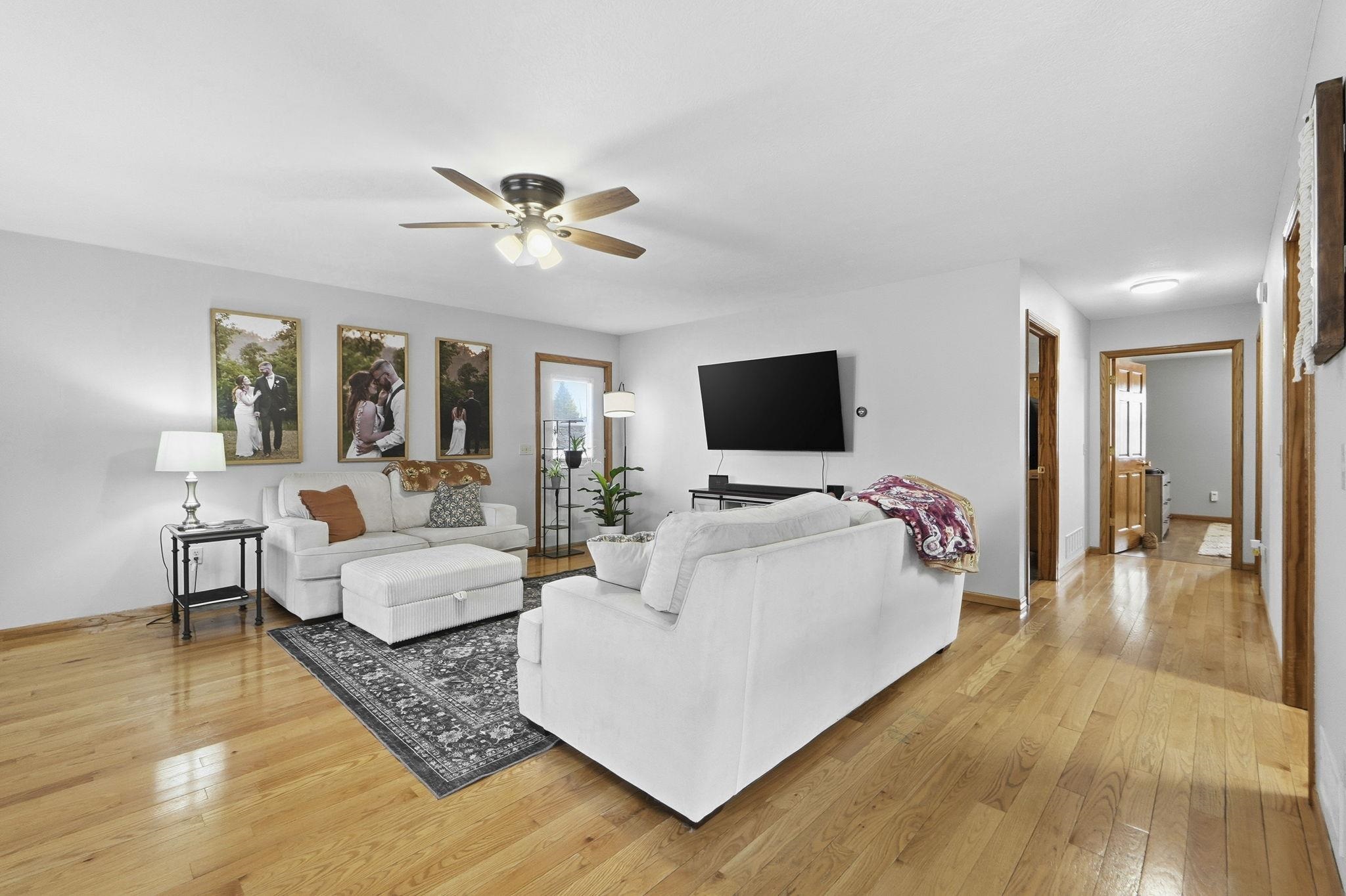 Living area with light wood-type flooring and ceiling fan