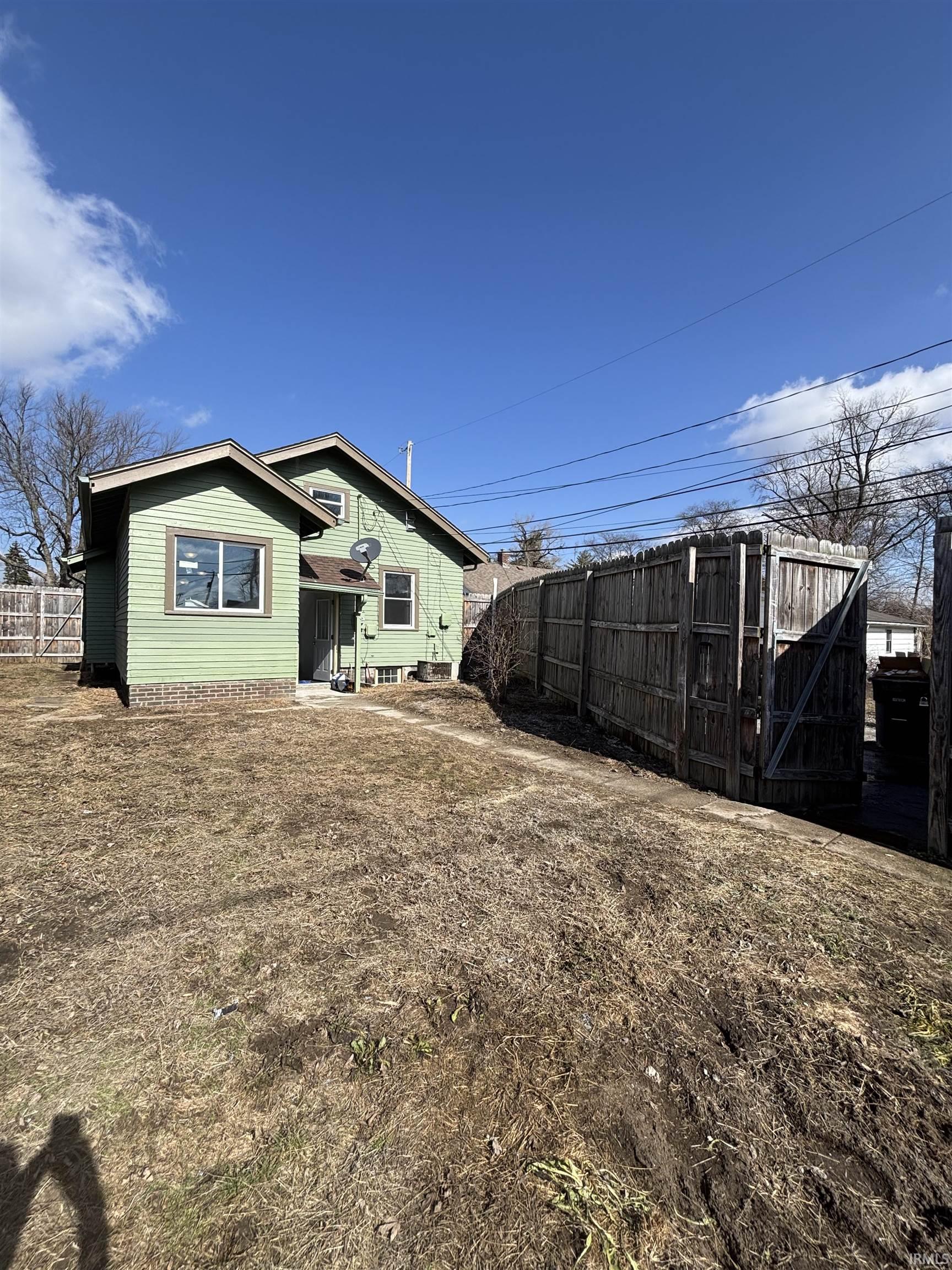 Rear view of house featuring a fenced backyard