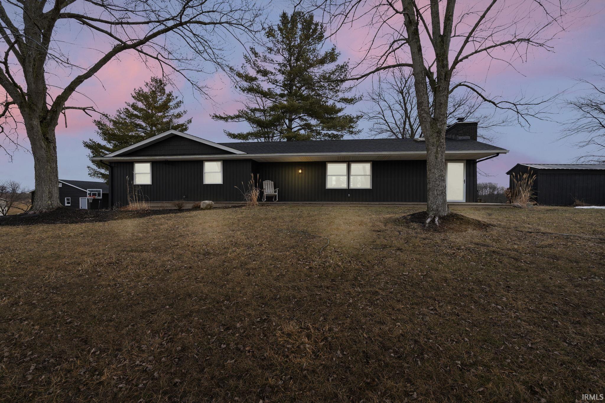 View of front of property with a chimney and a lawn