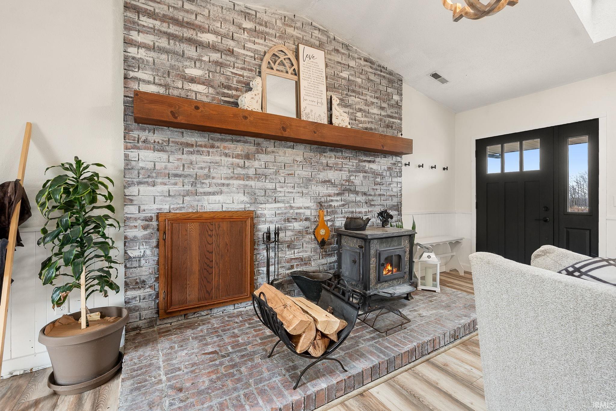 Living room with lofted ceiling and a wainscoted wall