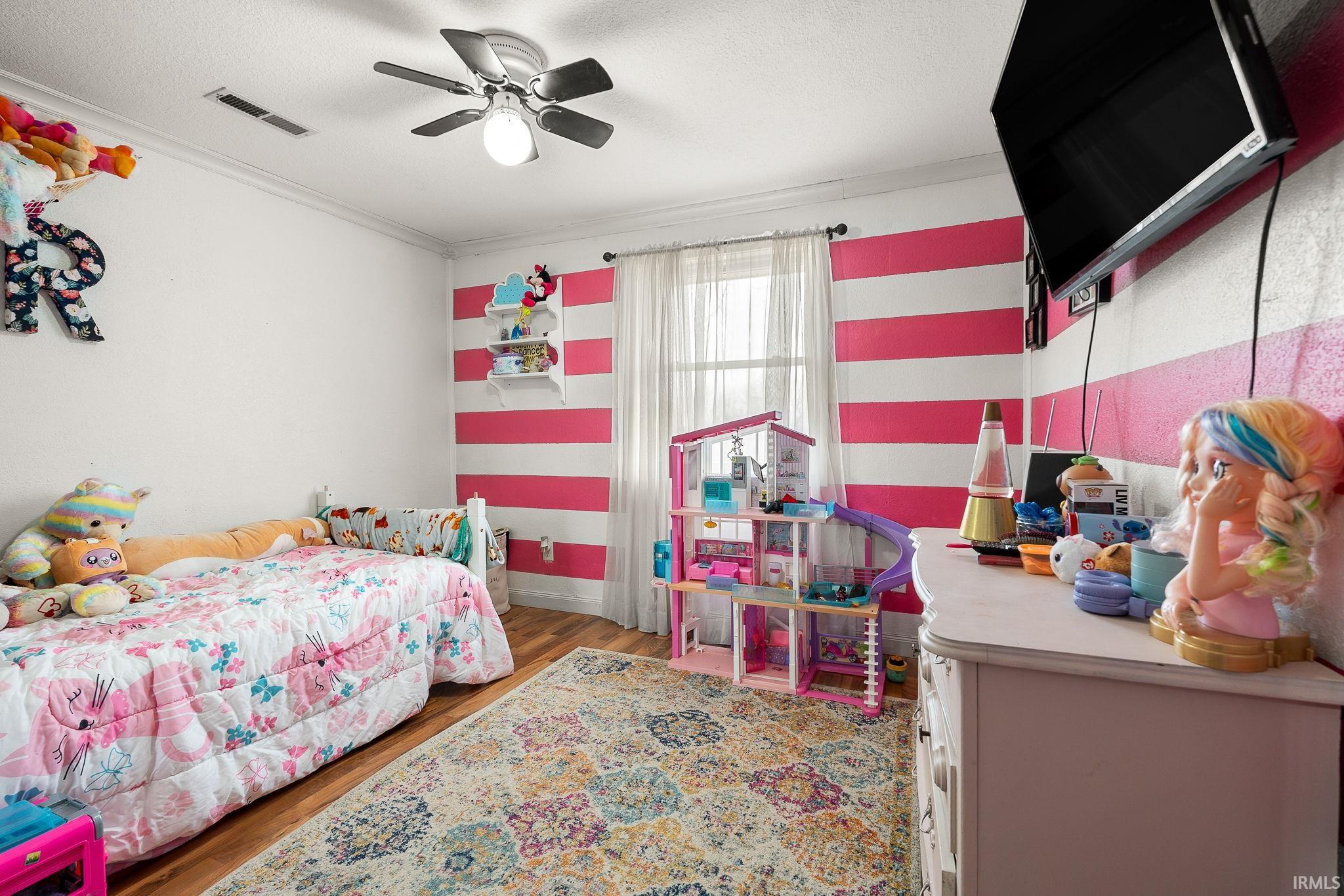 Bedroom featuring dark wood-style floors, a textured ceiling, a ceiling fan, and ornamental molding