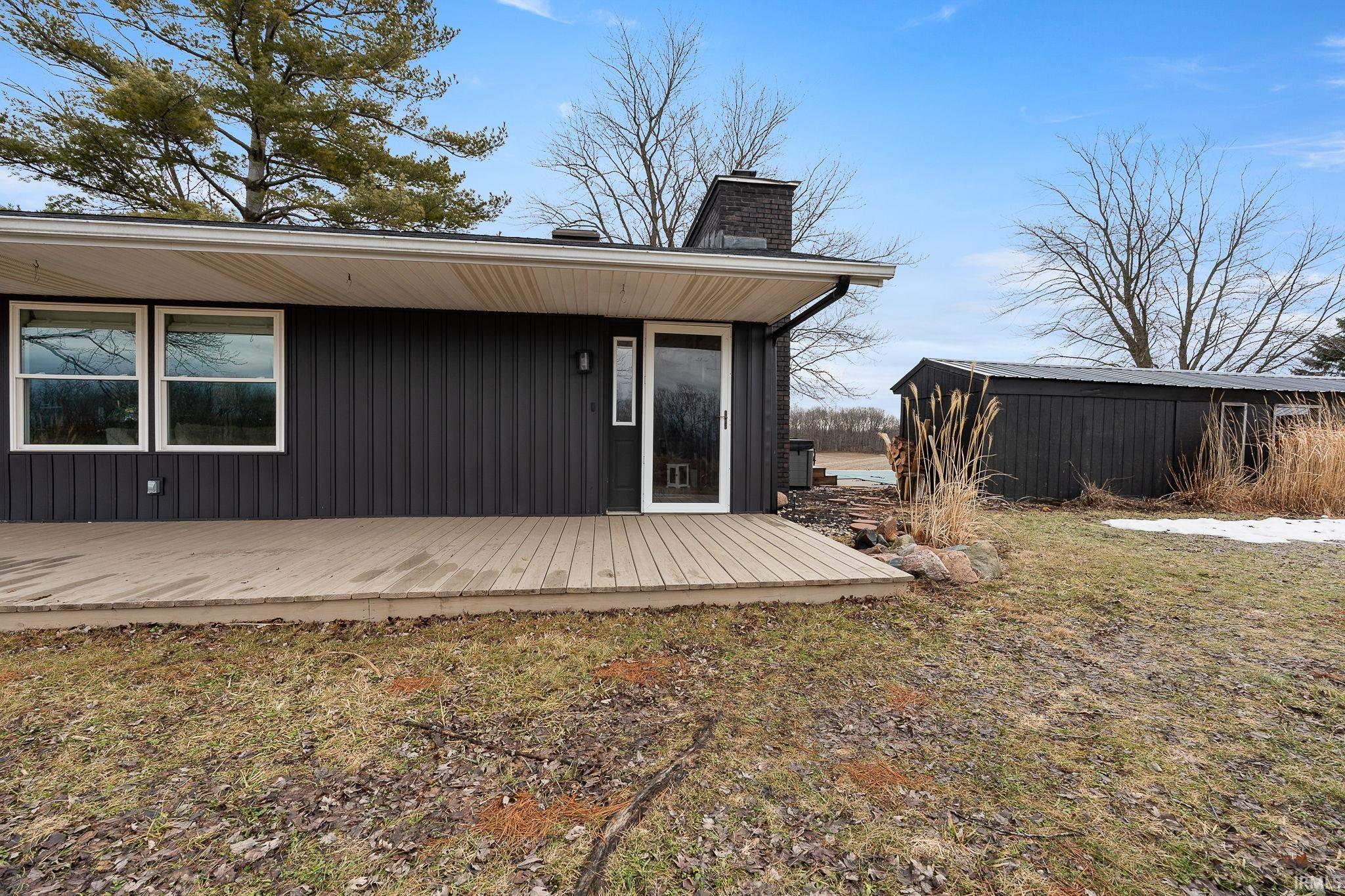 Rear view of house featuring a deck and a chimney