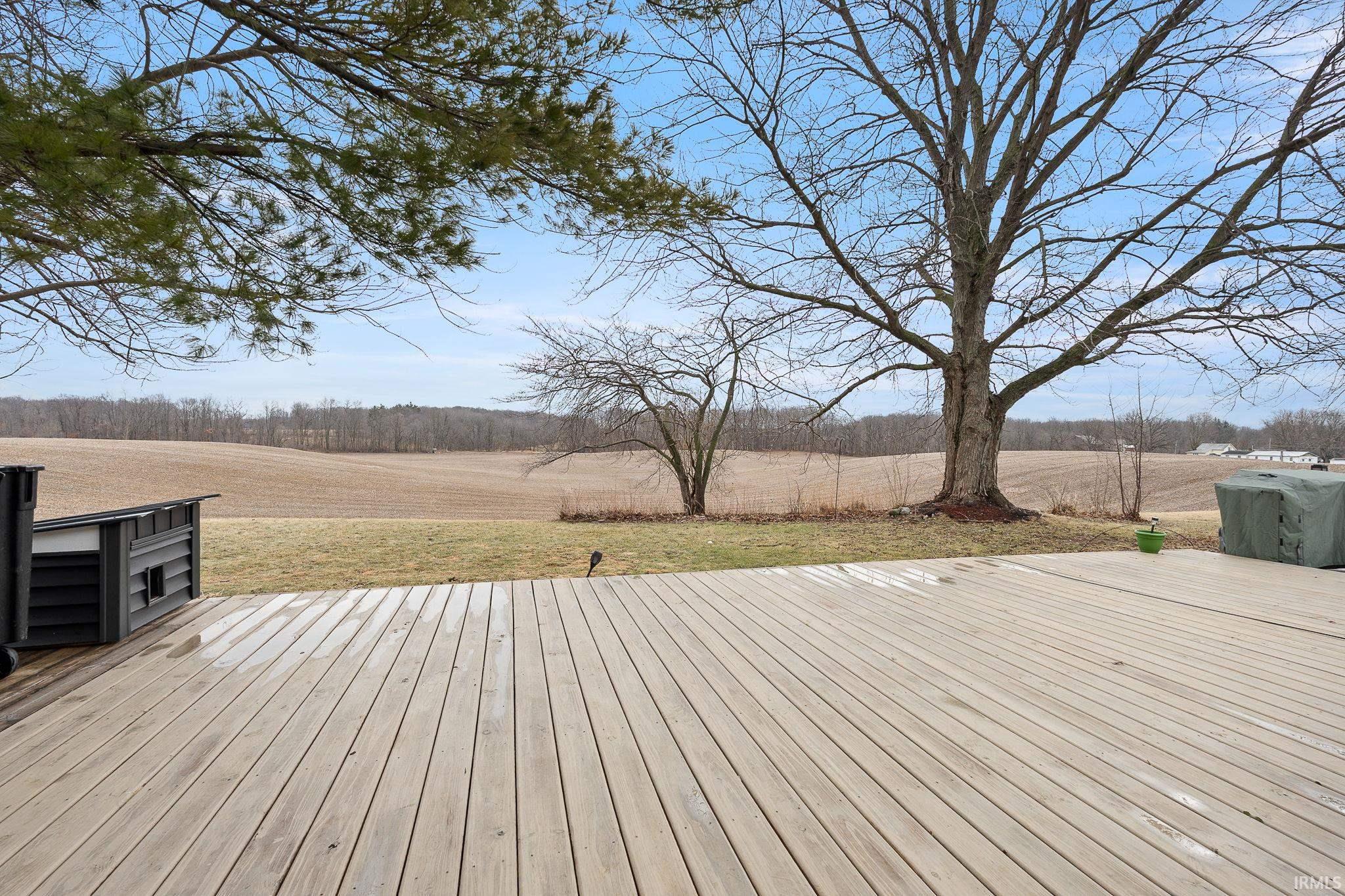 Wooden terrace with a lawn and a view of countryside