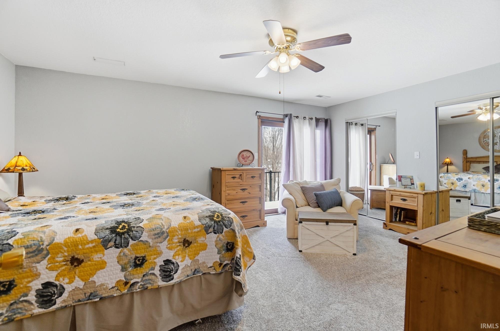 Bedroom featuring multiple closets, light colored carpet, and a ceiling fan