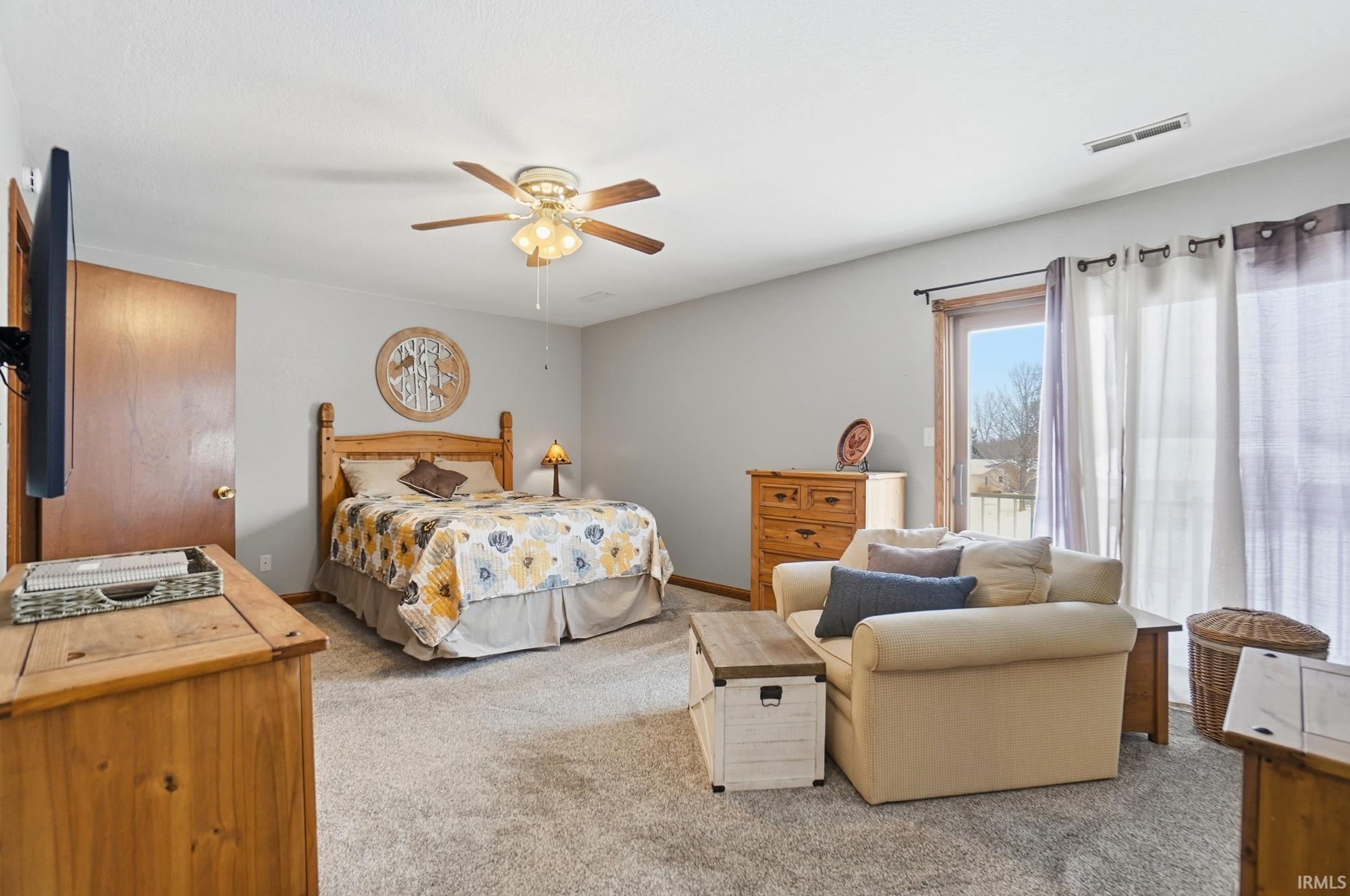 Bedroom with light carpet and a ceiling fan