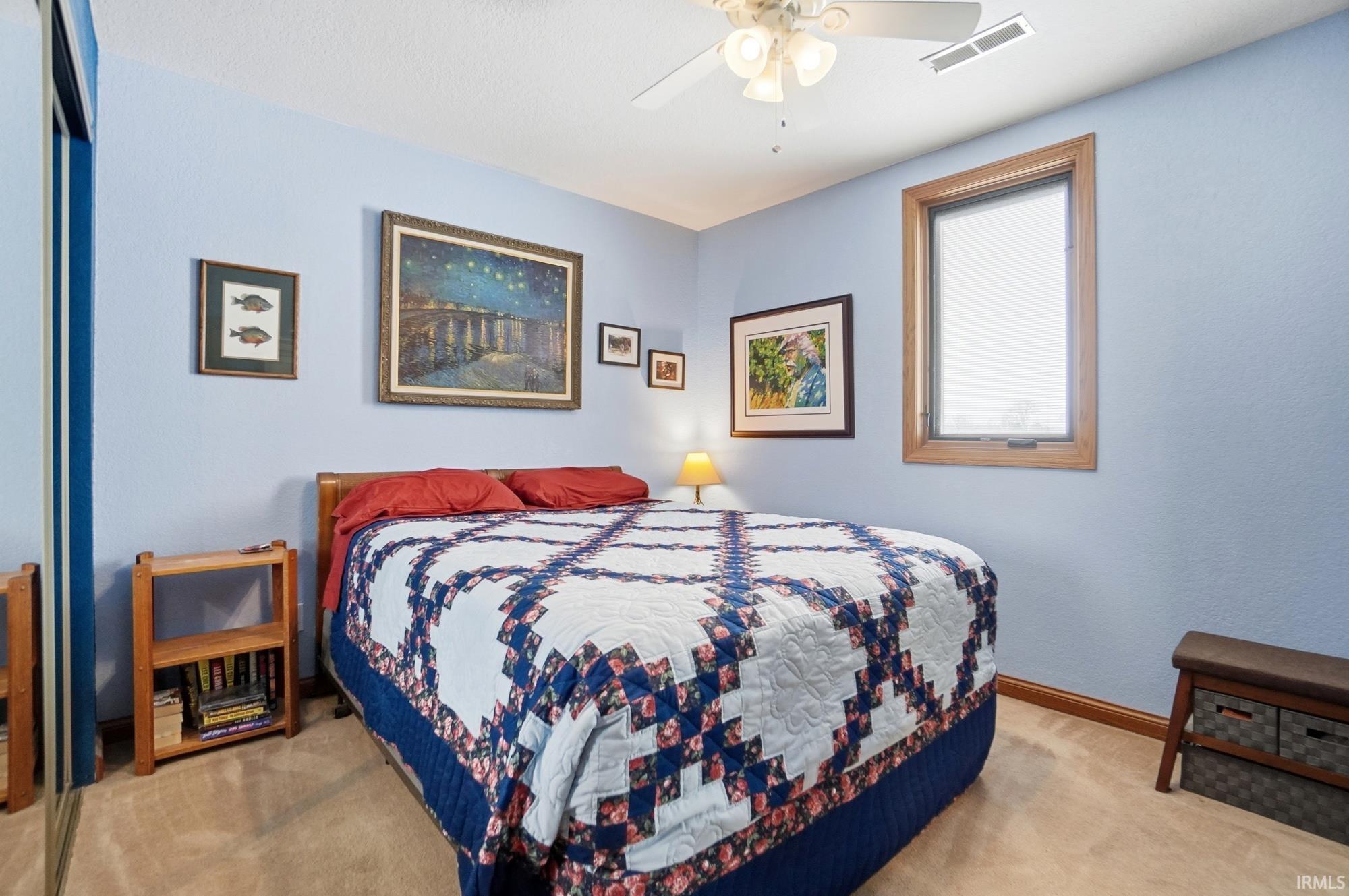 Bedroom with light colored carpet, a ceiling fan, and a closet