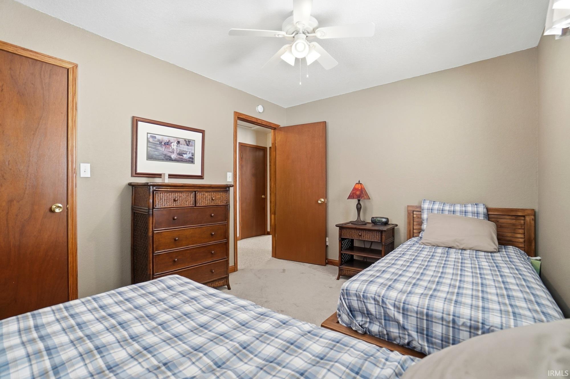 Bedroom featuring a ceiling fan and light colored carpet
