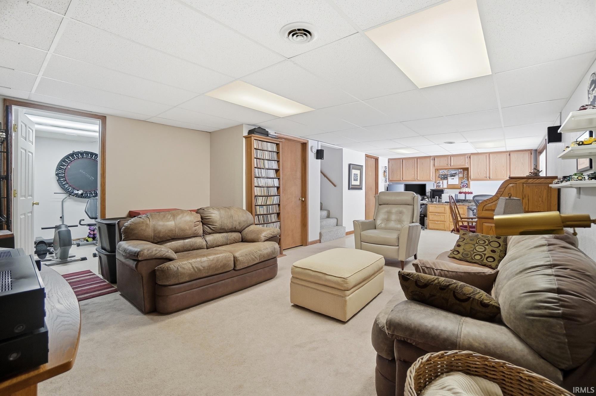 Living room featuring a paneled ceiling and carpet flooring