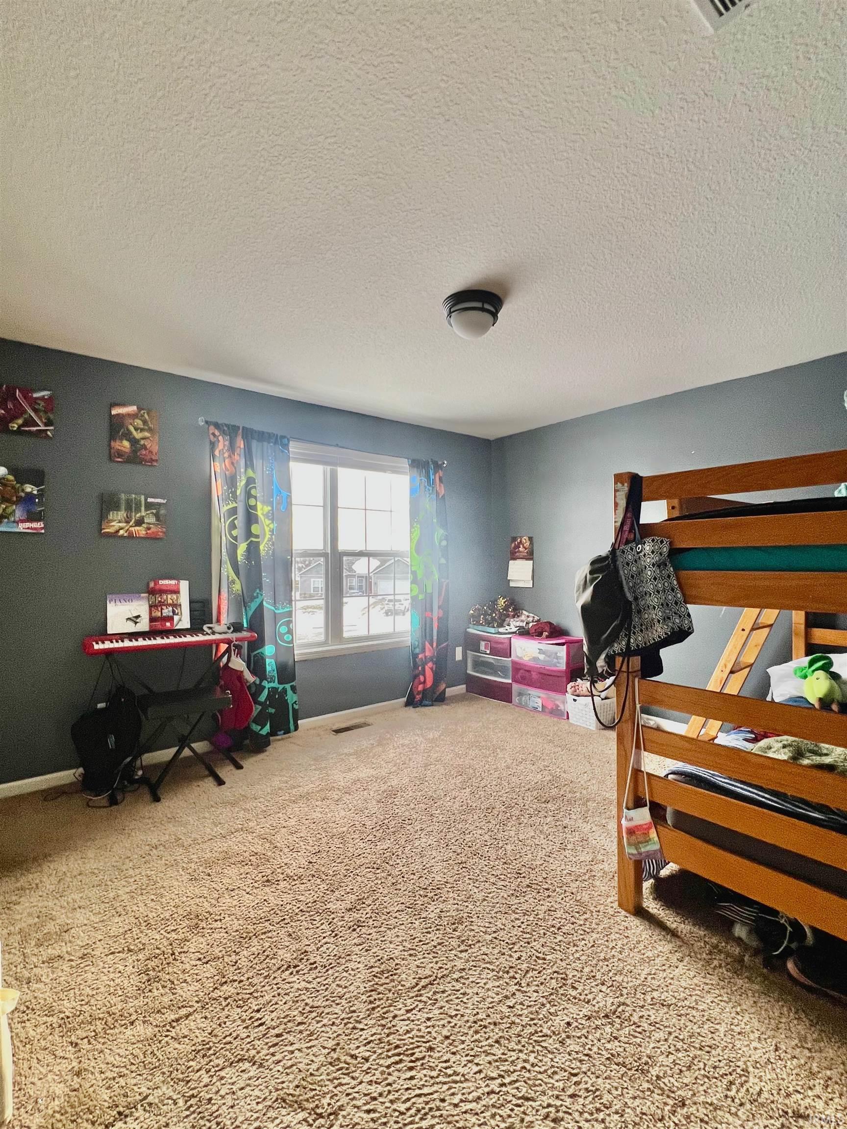 Bedroom with carpet floors and a textured ceiling