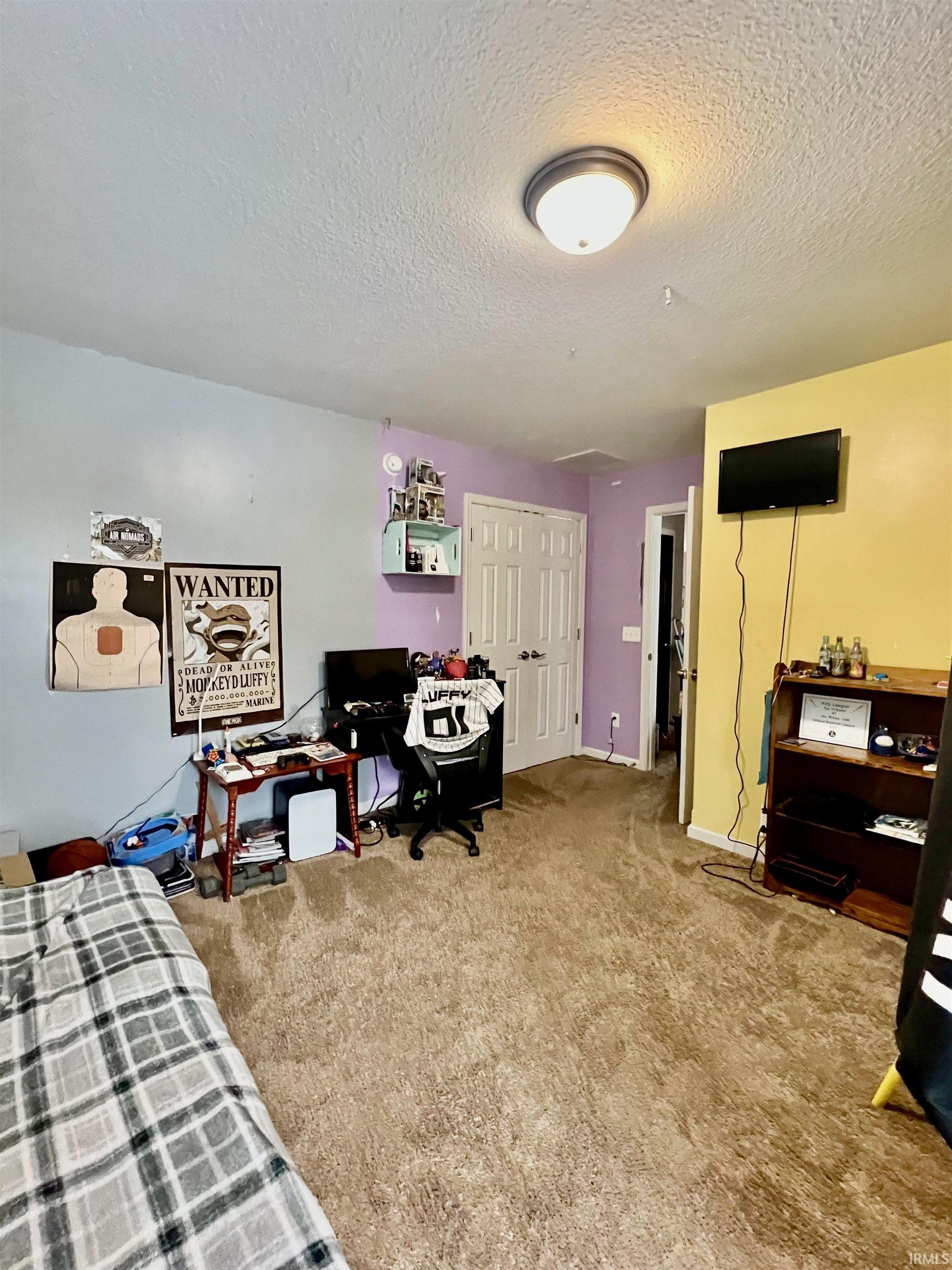 Bedroom with light carpet and a textured ceiling