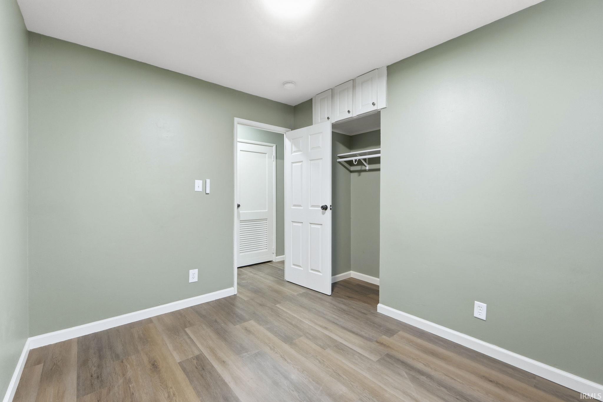 Unfurnished bedroom featuring light wood-style floors and a closet