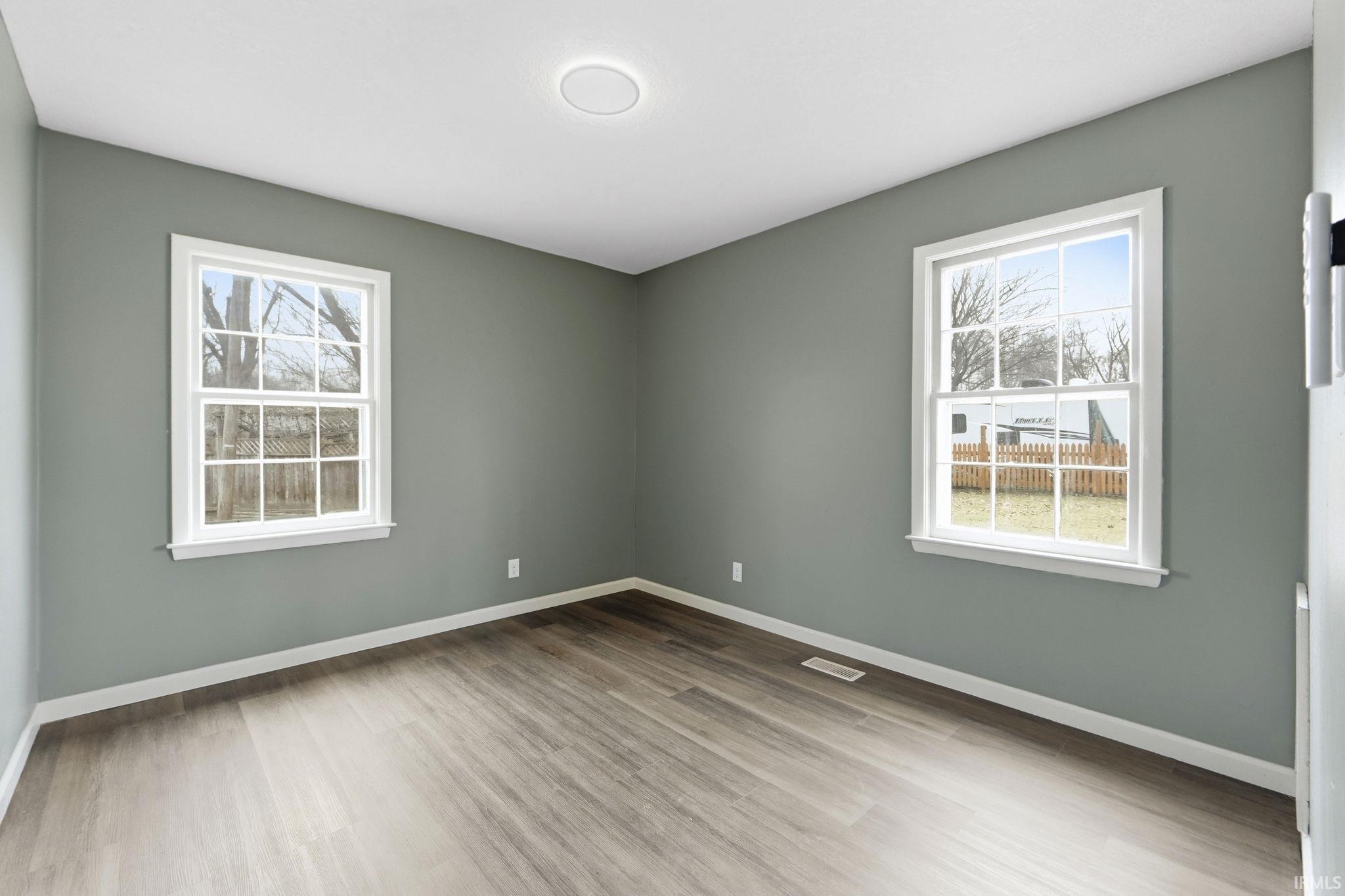 Spare room with baseboards and light wood finished floors