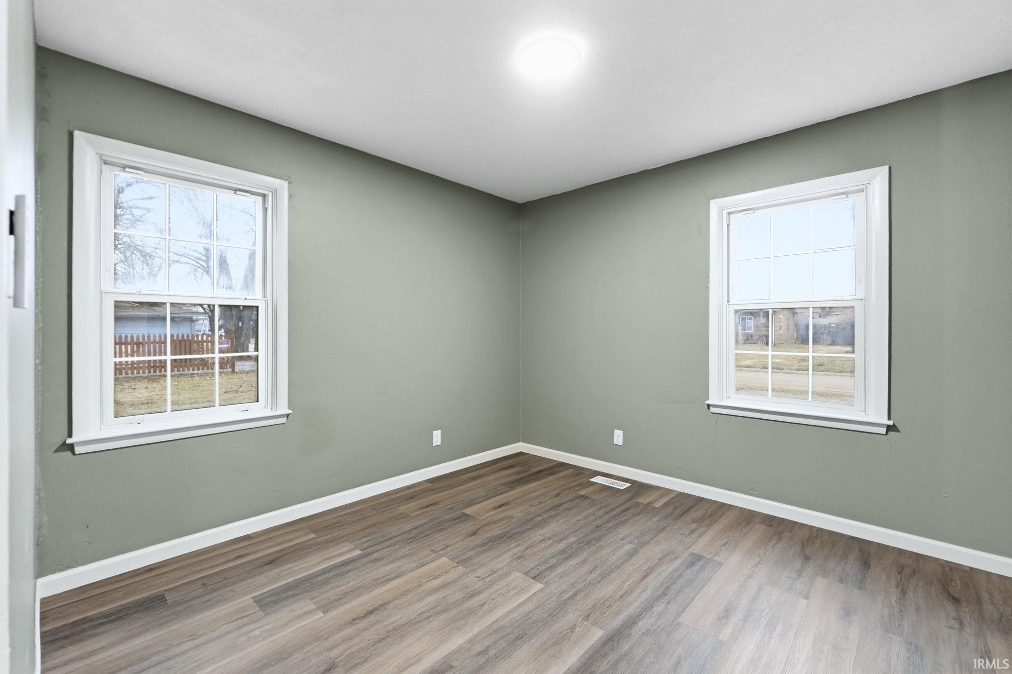Spare room with wood finished floors and healthy amount of natural light