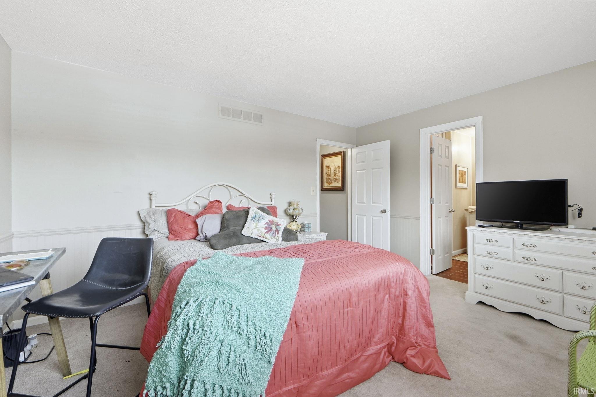 Carpeted bedroom with wainscoting