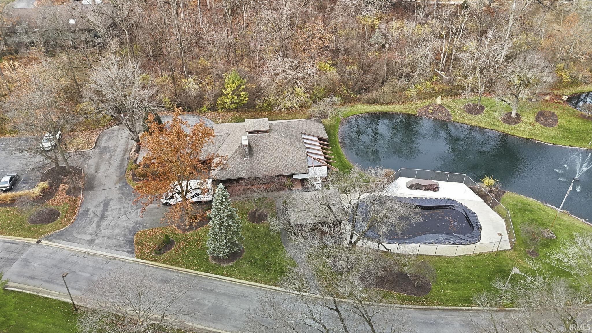 Aerial view of property and surrounding area with a nearby body of water