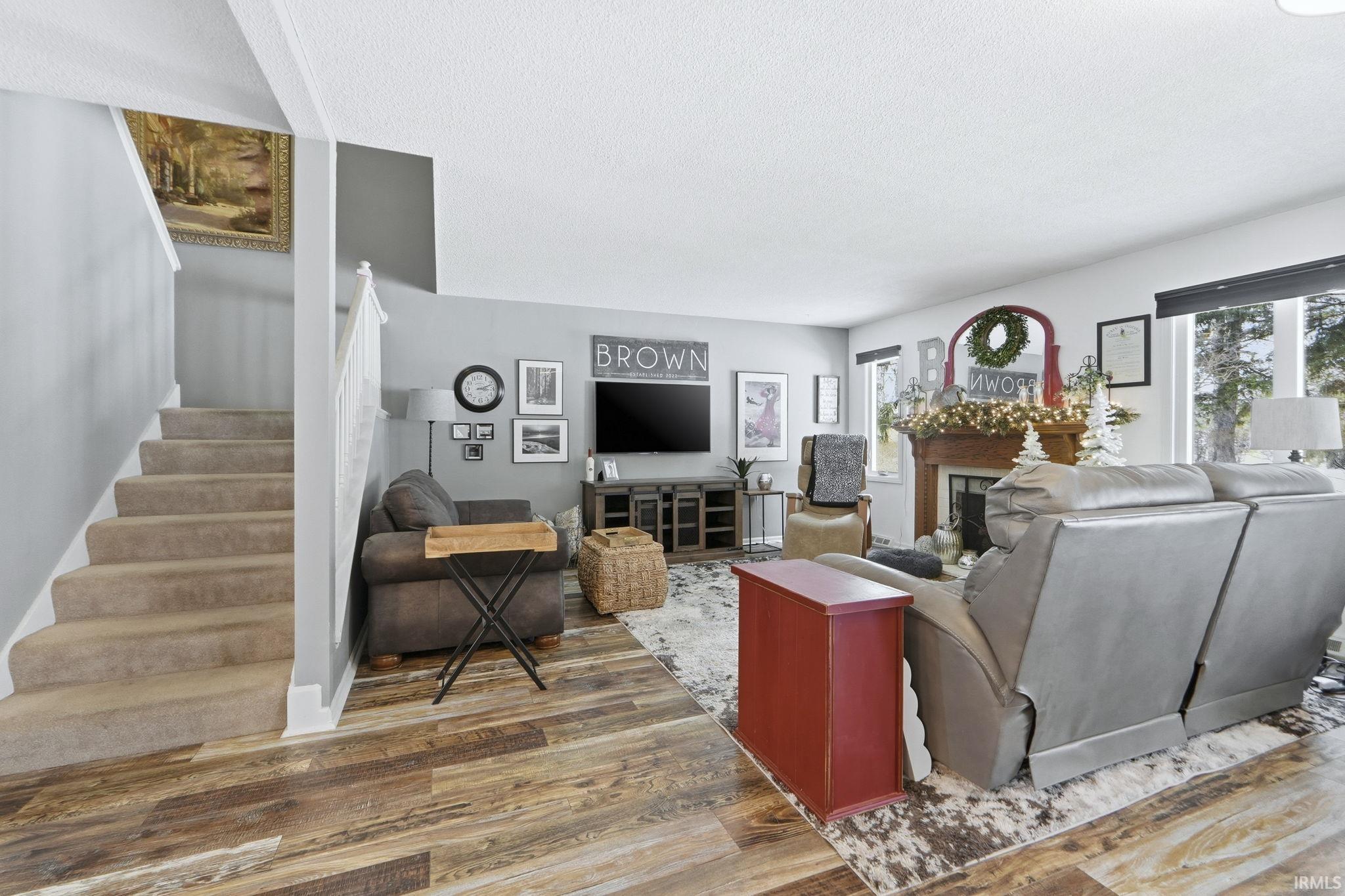 Living area with wood finished floors, a textured ceiling, and a fireplace
