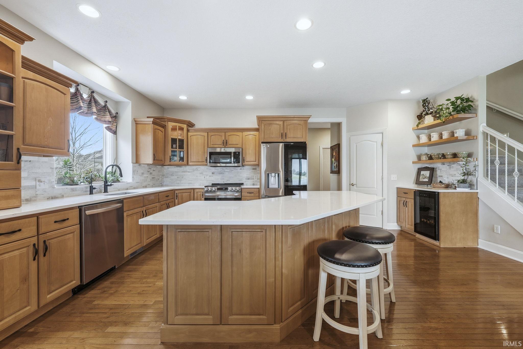 Kitchen with open shelves, backsplash, stainless steel appliances, dark wood-style flooring, and recessed lighting